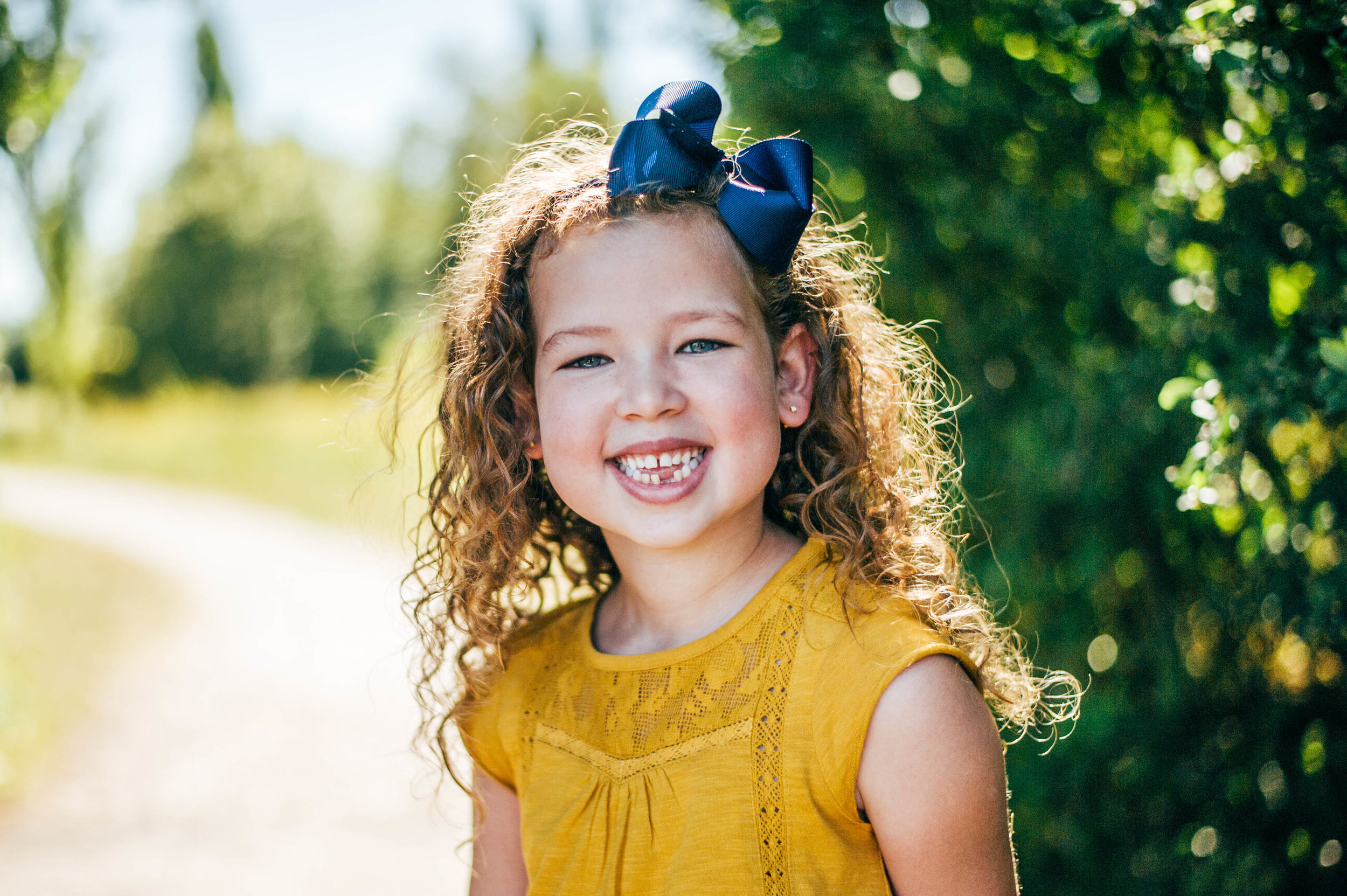 Little girl smiles on bridge Essex UK Natural Documentary Portrait Photographer