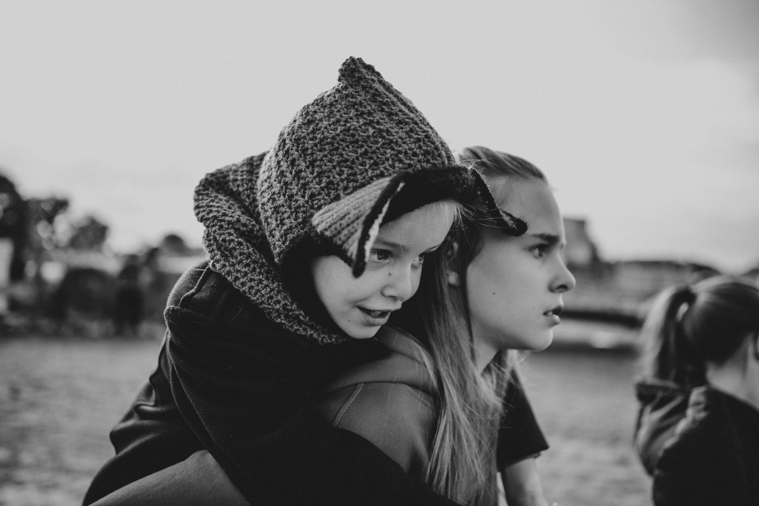 Little girl in Fox hat on sisters back Essex UK Documentary Portrait Photographer