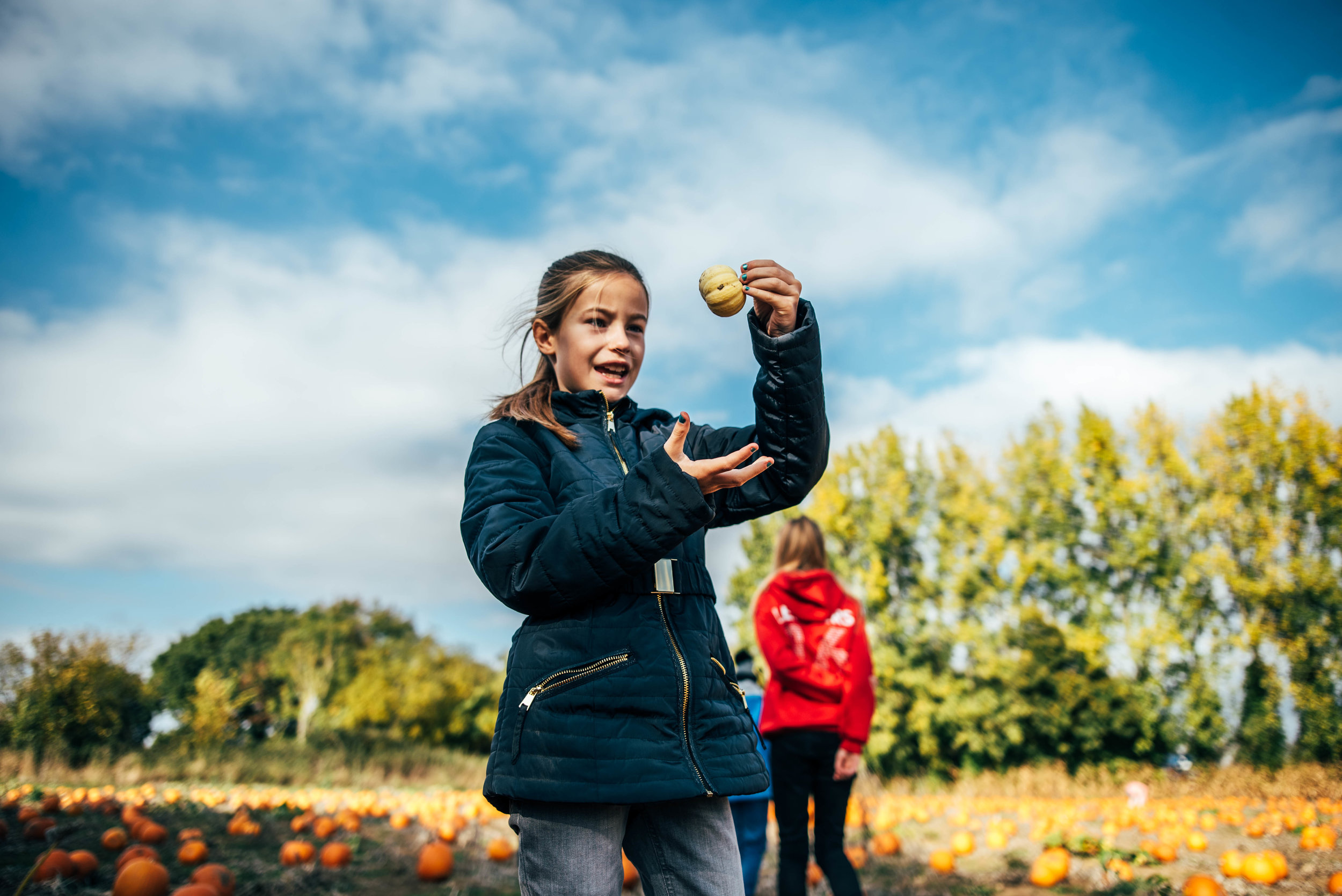 Young girl holds pumpkin up Essex UK Documentary Portrait Photographer