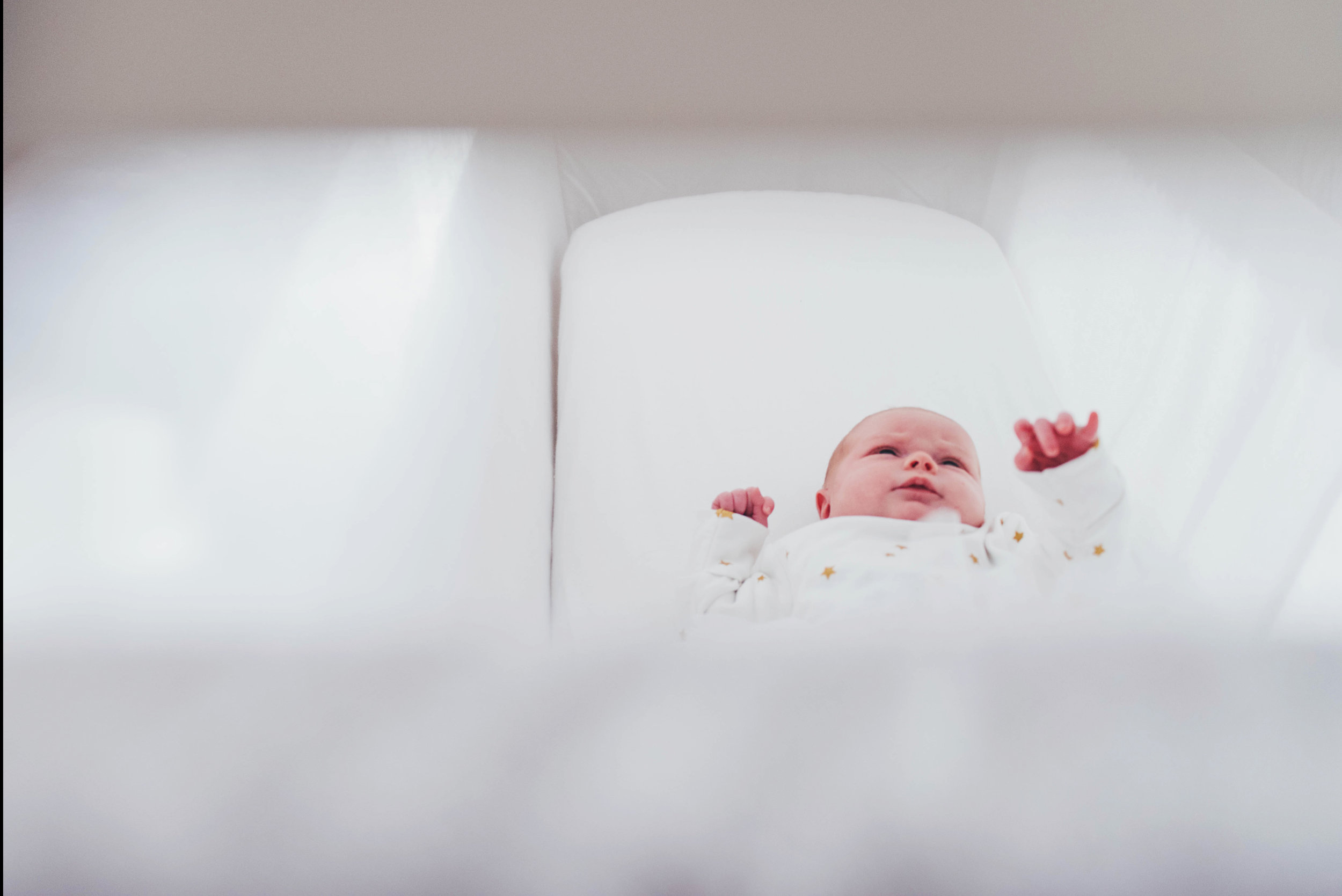 Newborn baby girl in crib At Home Lifestyle Shoot Essex UK Documentary Portrait Photographer