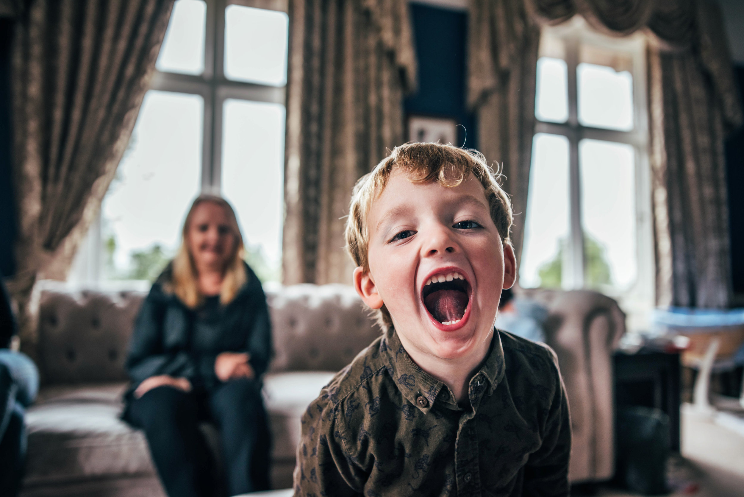 Little boys laugh in camera At Home Lifestyle Shoot Essex UK Documentary Portrait Photographer