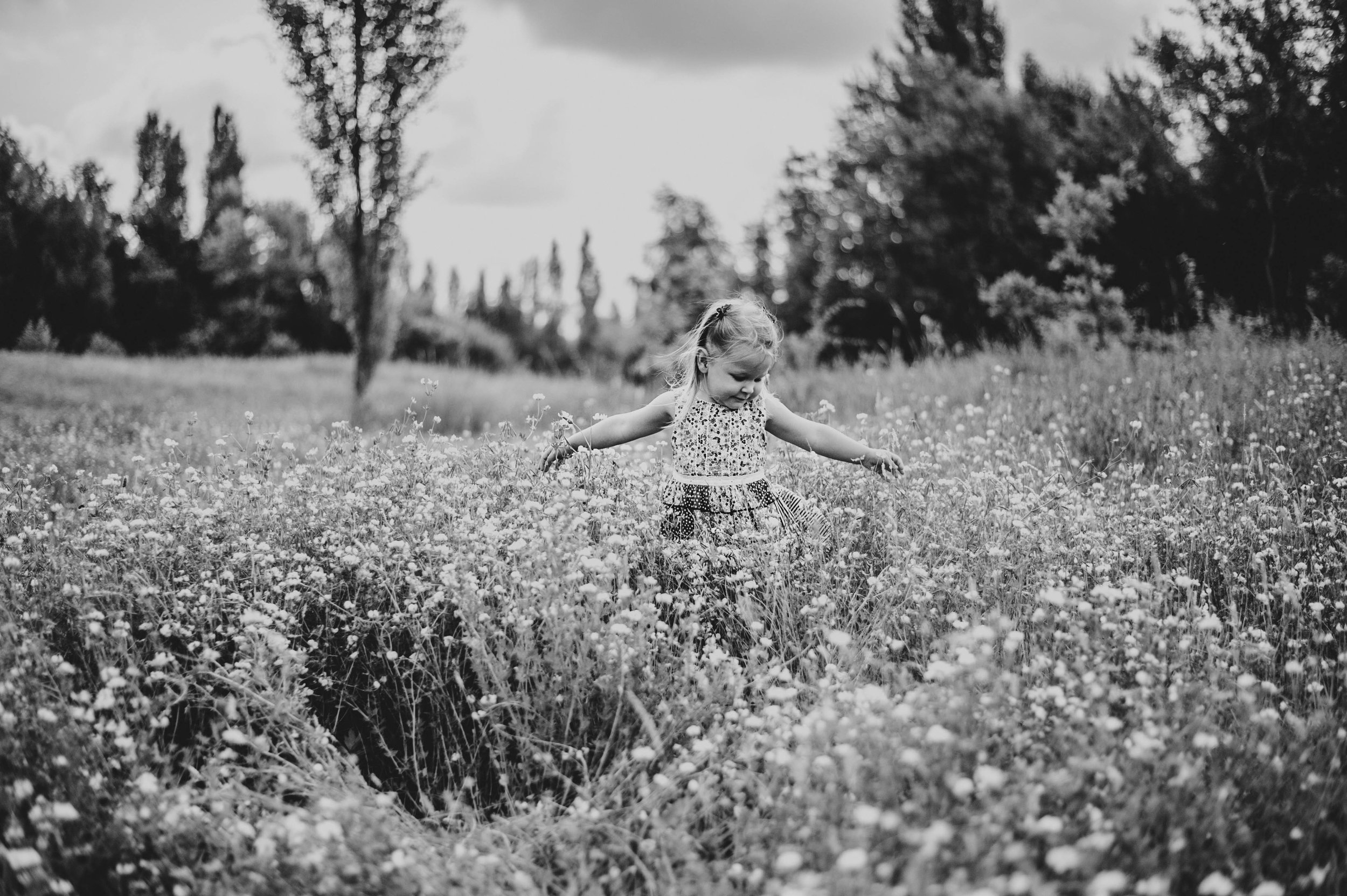 Little girl twirls in Summer Meadow Lifestyle Shoot Essex UK Documentary Portrait Photographer