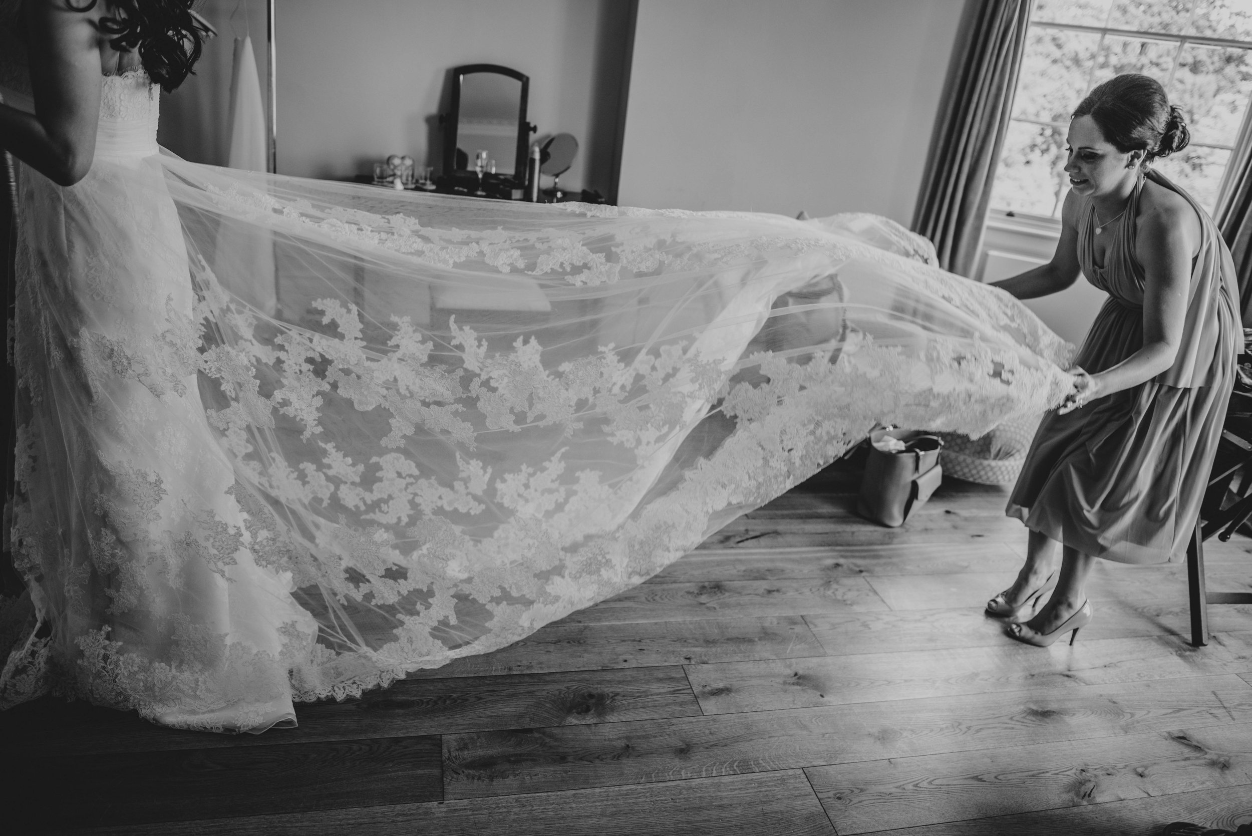 Bridesmaid holds out veil at Hylands House Chelmsford Essex UK Documentary Wedding Photographer 