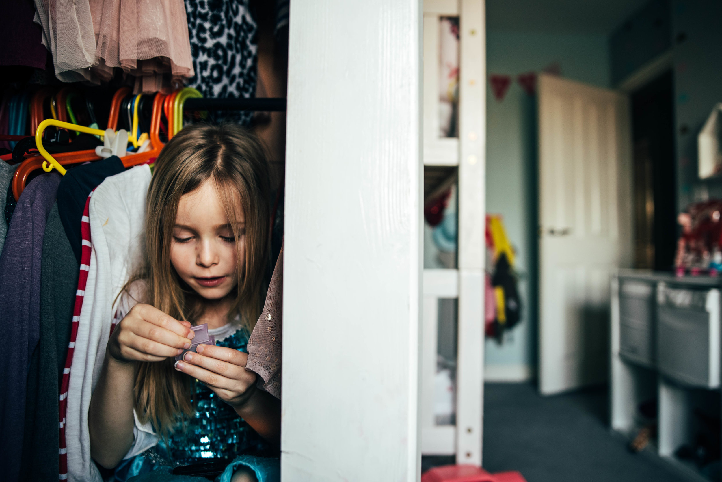 Little girl plays in her wardrobe Essex UK Documentary Photographer