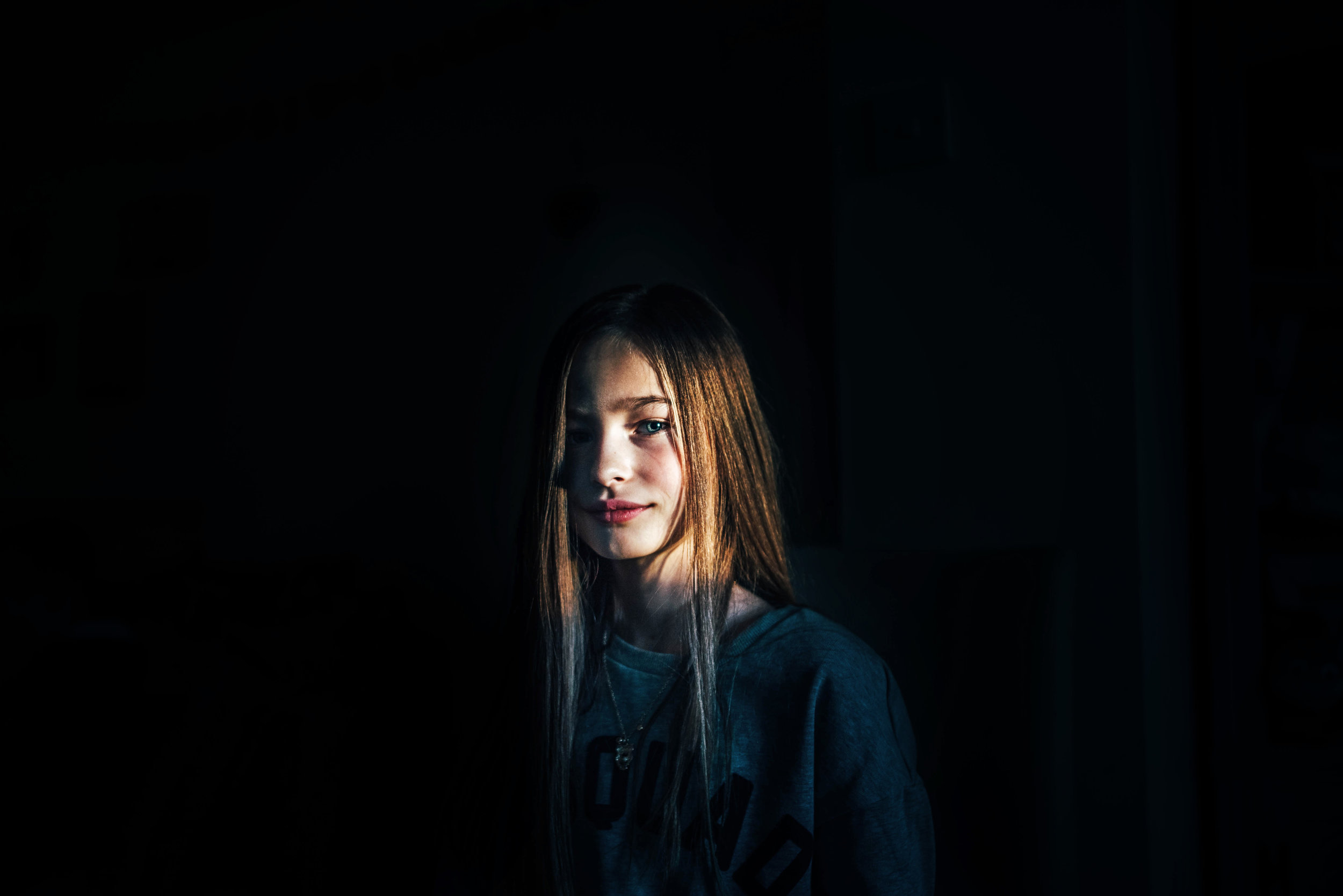 Girl lit by beam of Winter light Essex UK Documentary Photographer