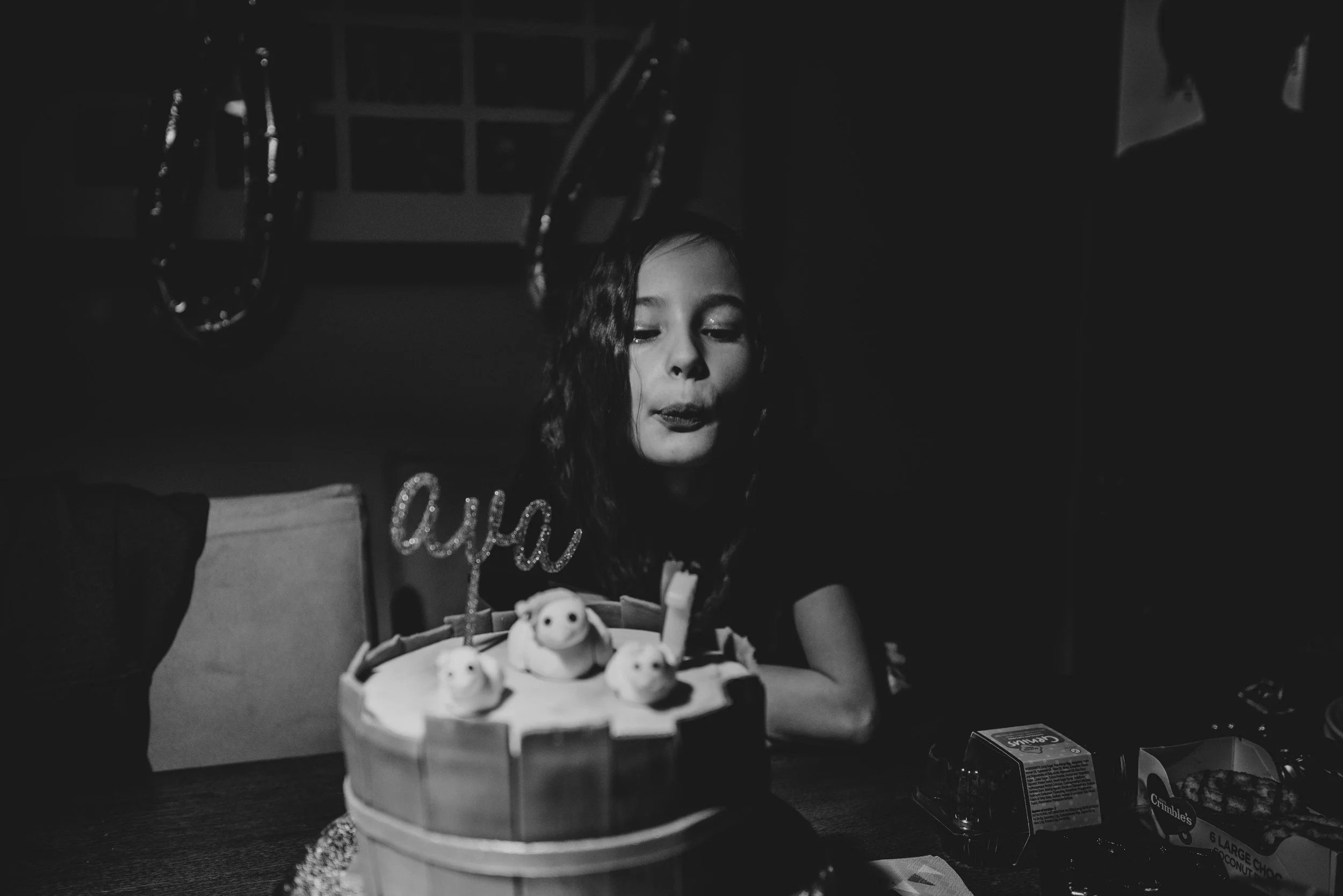 Young girl blows out birthday candles Essex UK Documentary Photographer