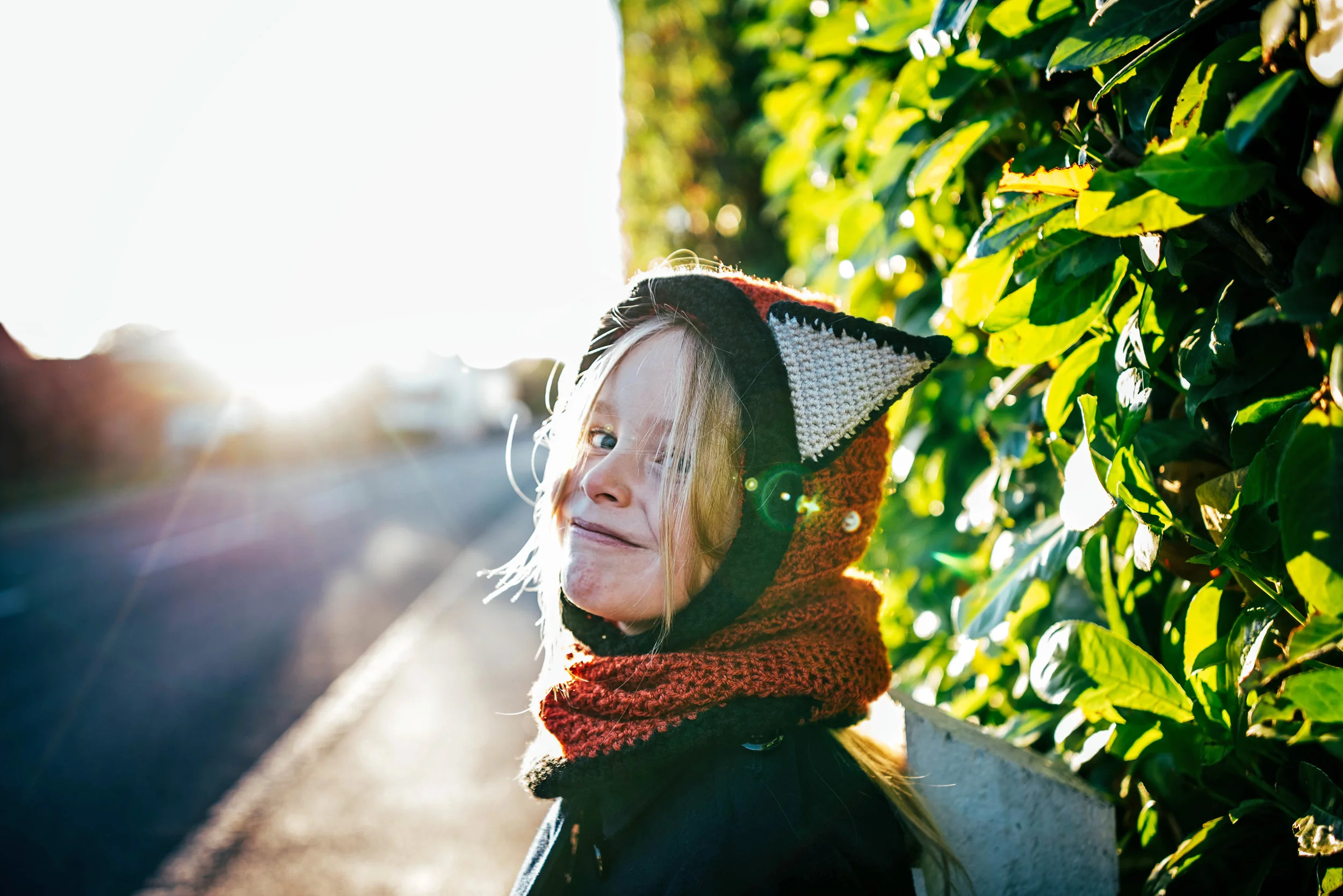 Little girl in fox hat in sun flare Essex UK Documentary Photographer