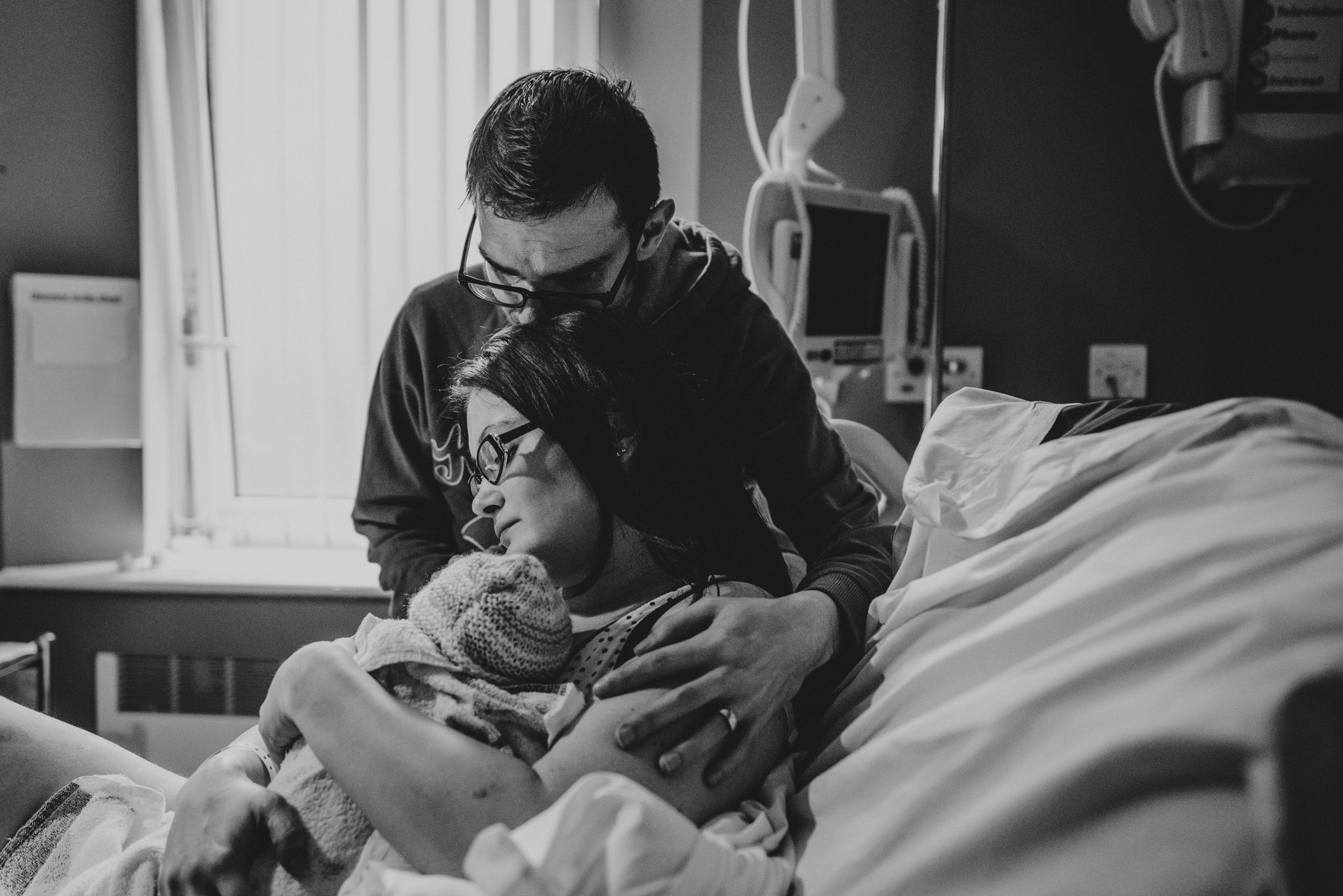 New Parents cuddle newborn baby in delivery room Essex UK Documentary Birth Photographer