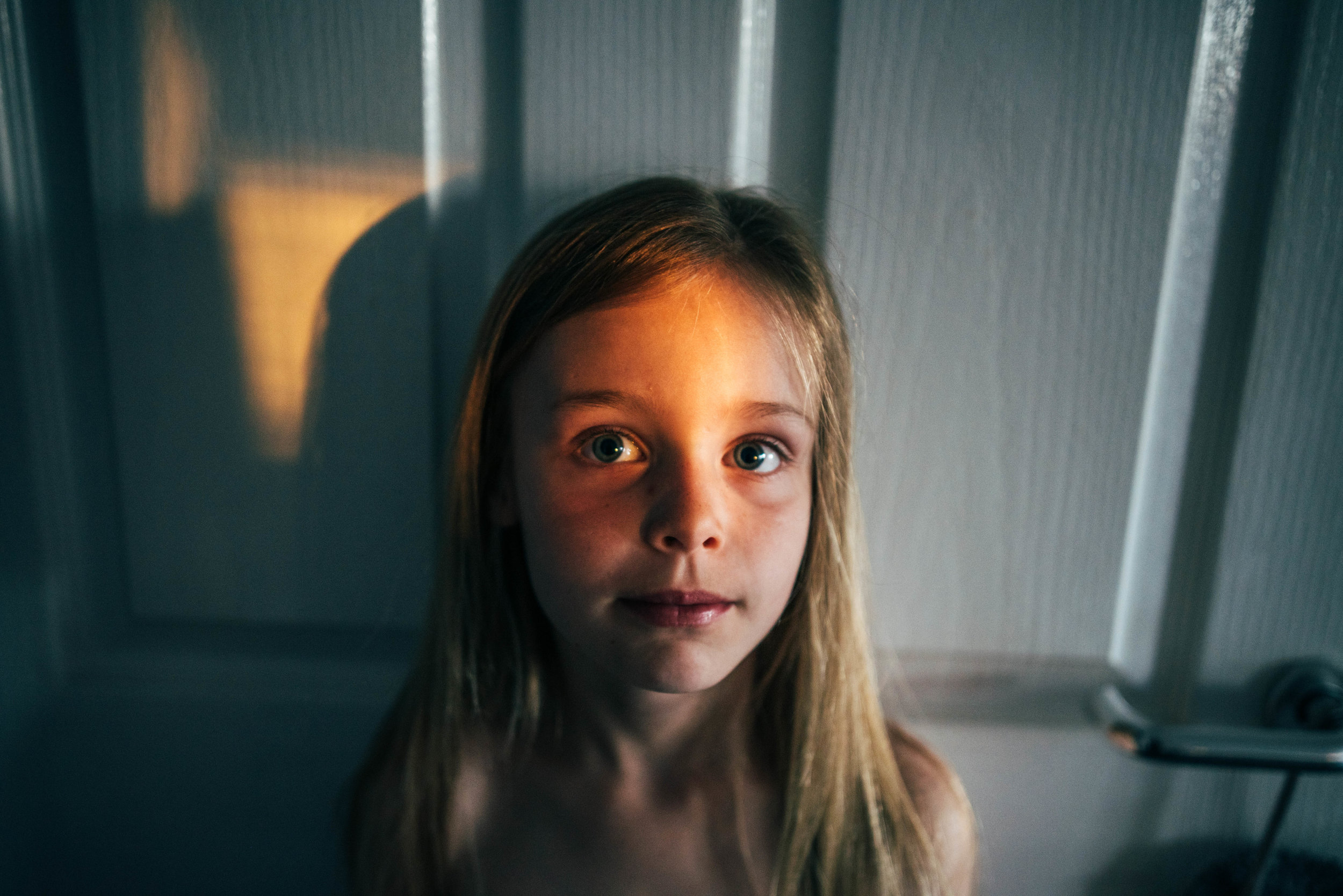 Little girl in pocket of light Essex UK Documentary Lifestyle Portrait Photographer