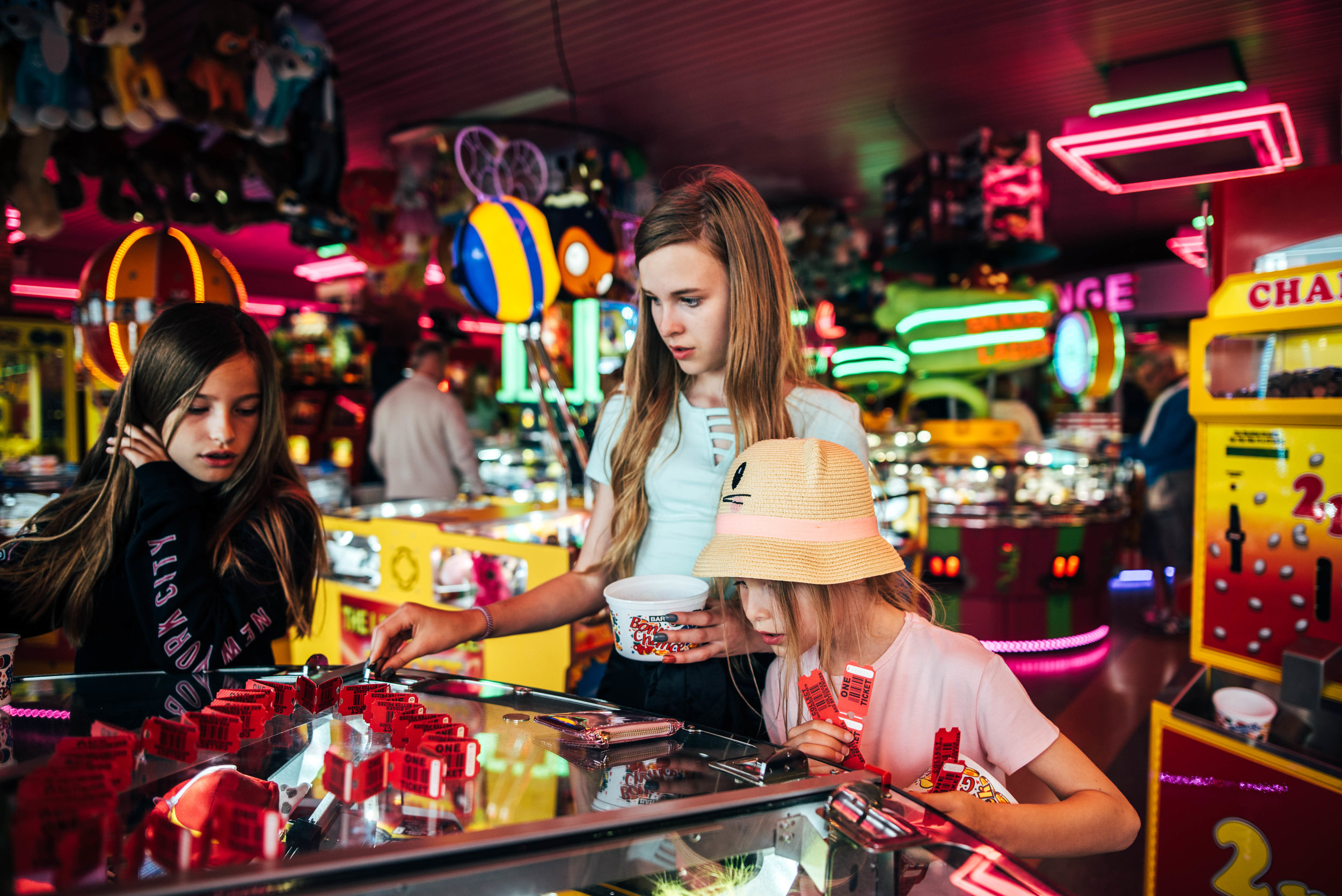 Three girls in amusement arcade penny slots Essex UK Documentary Lifestyle Portrait Photographer 