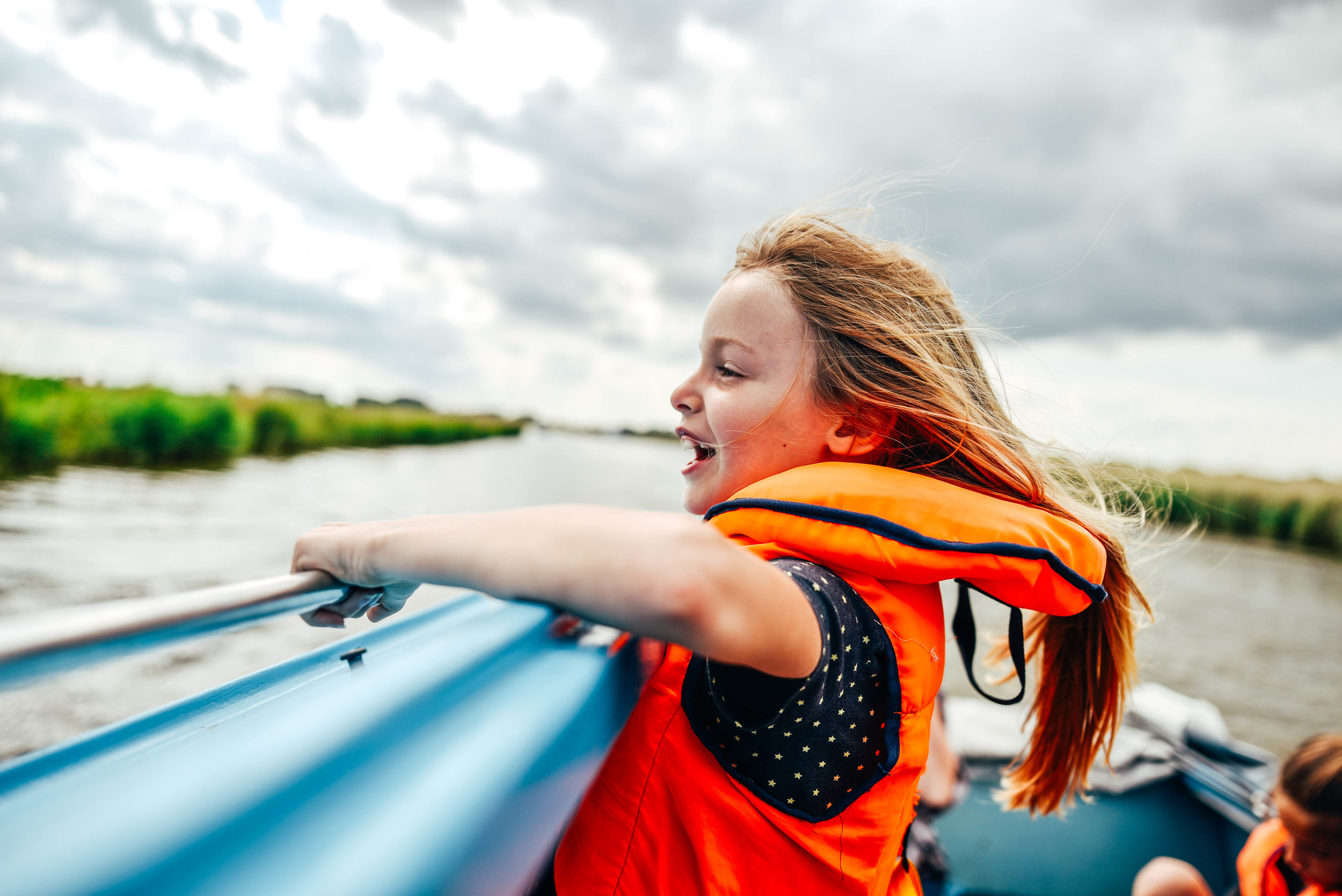 Little girl in life jacket on river boat Essex UK Documentary Lifestyle Portrait Photographer