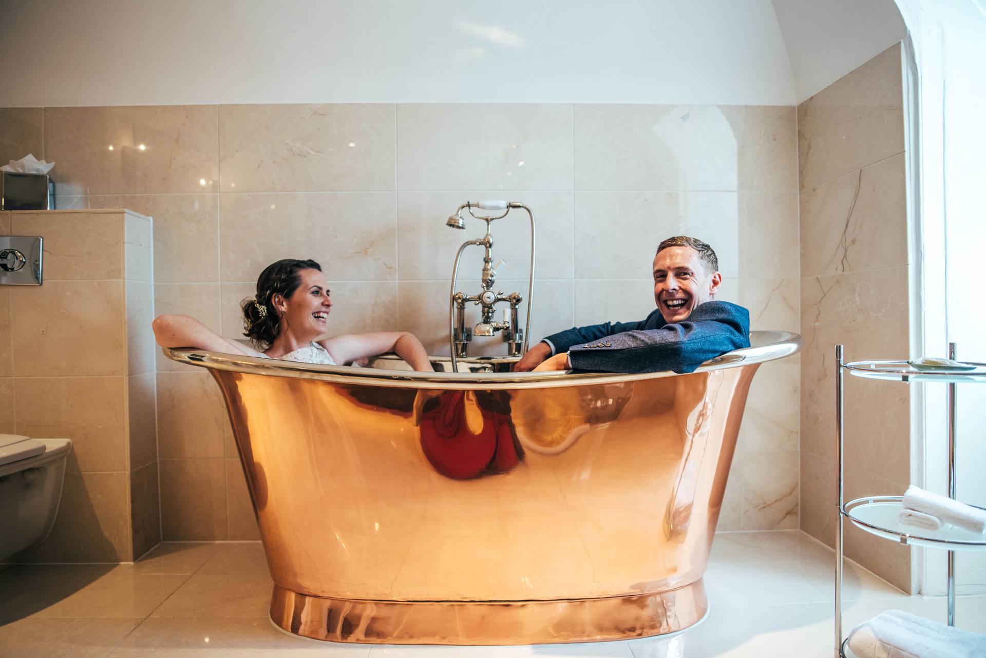 Alternative diy wedding on a boat with steam fairground Essex UK Documentary Wedding Photographer Bride and Groom in copper bath