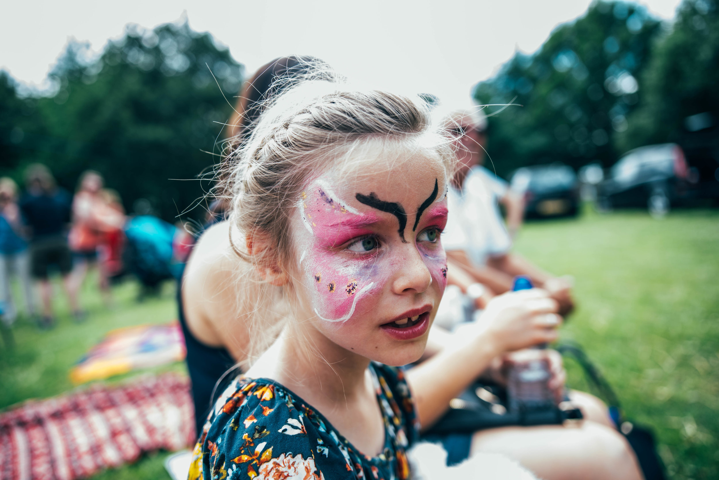 Young girl with butterfly face paint at festival Essex UK Documentary Portrait Photographer