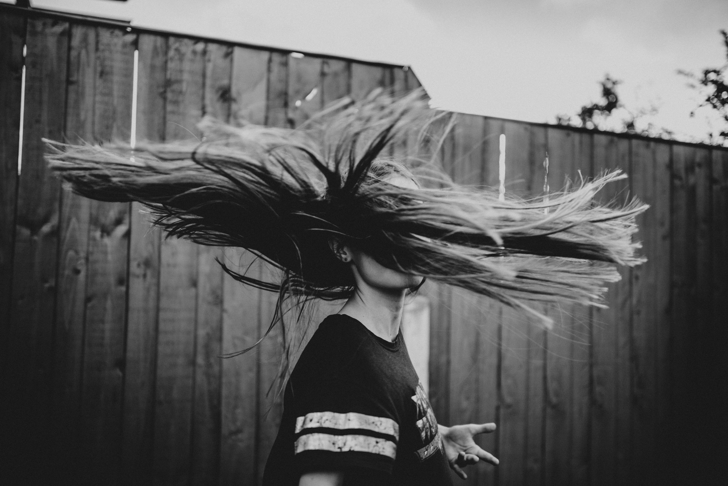 Girl dancing in back garden at sunset Essex UK Documentary Lifestyle Wedding Photographer