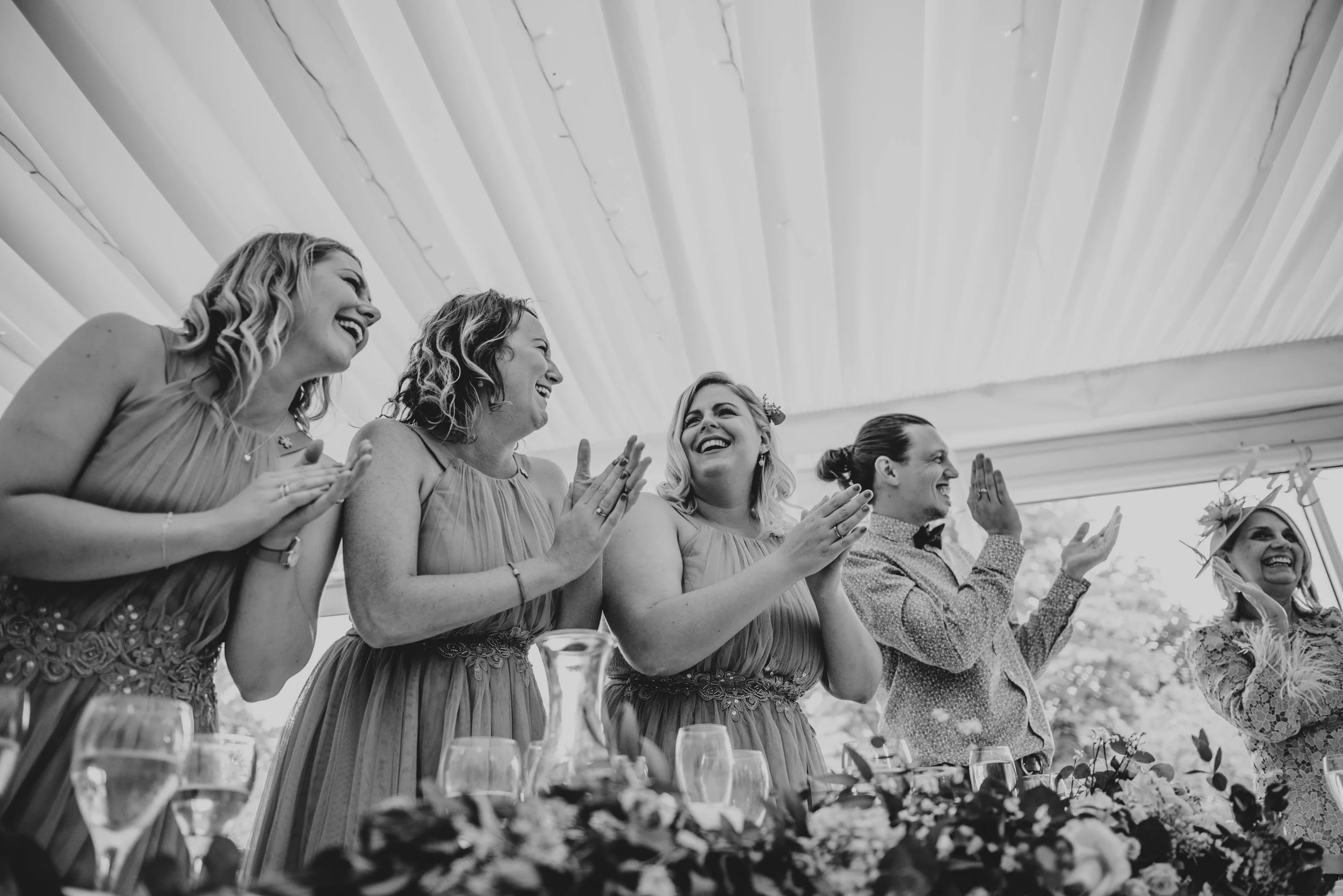 Bridesmaids applaud speeches at Fennes Essex Documentary Wedding Photographer
