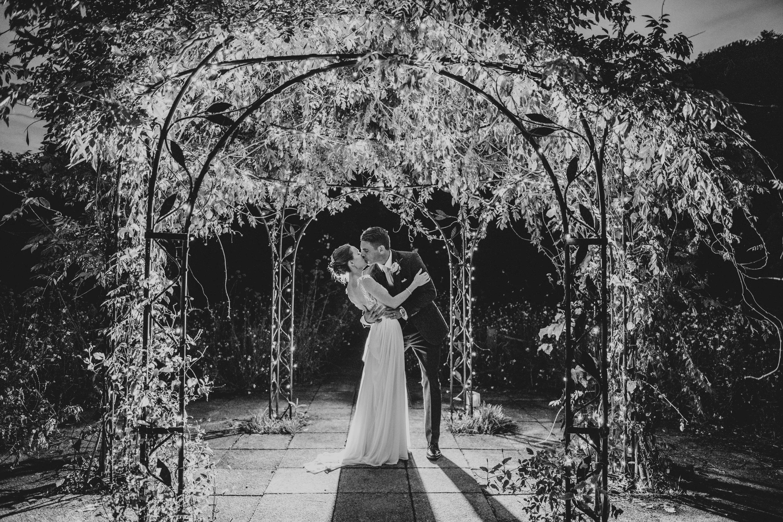 Bride and Groom under pergola at night Gaynes Park Essex Documentary Wedding Photographer