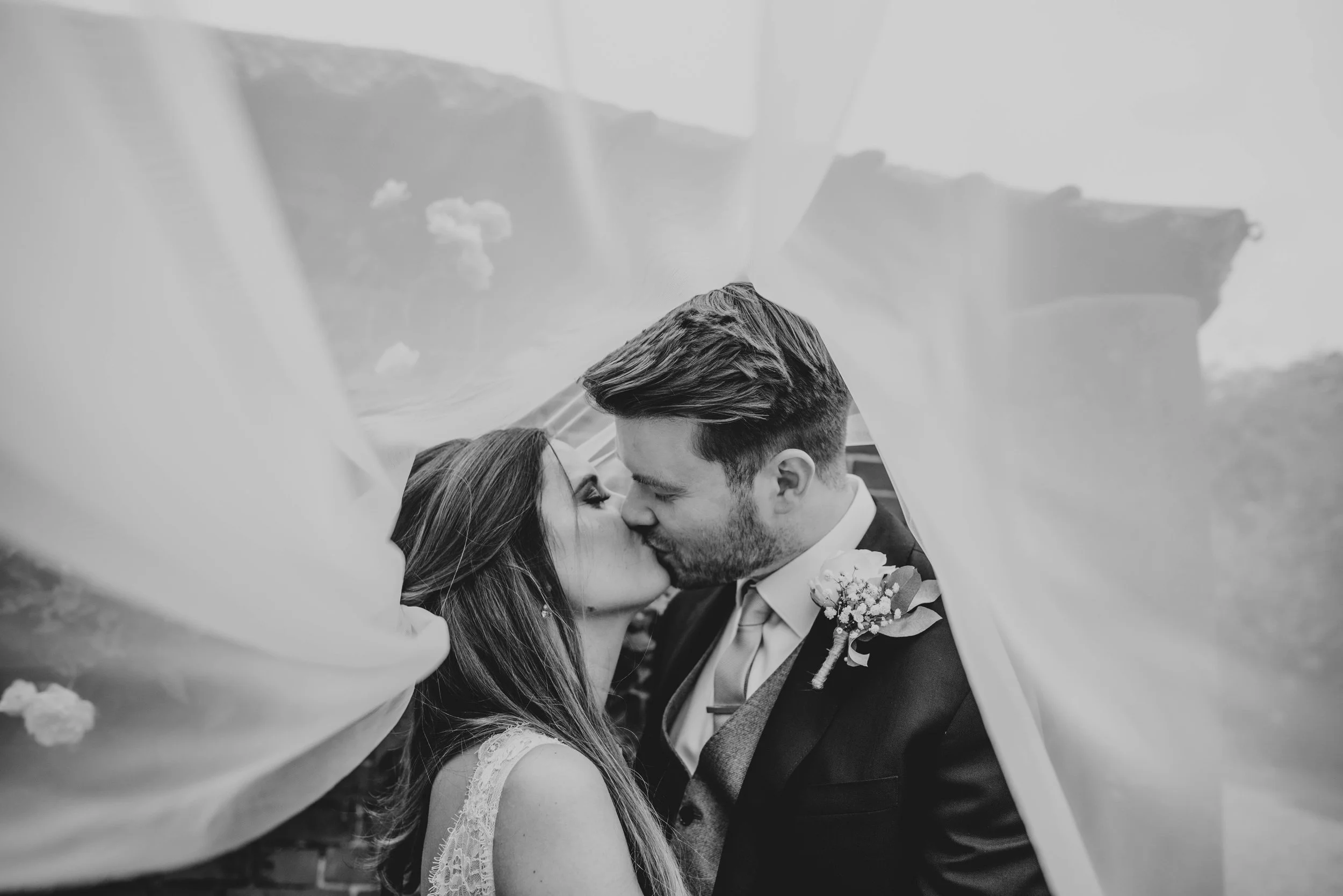 Bride and Groom kiss under veil Blake Hall Essex Documentary Wedding Photographer