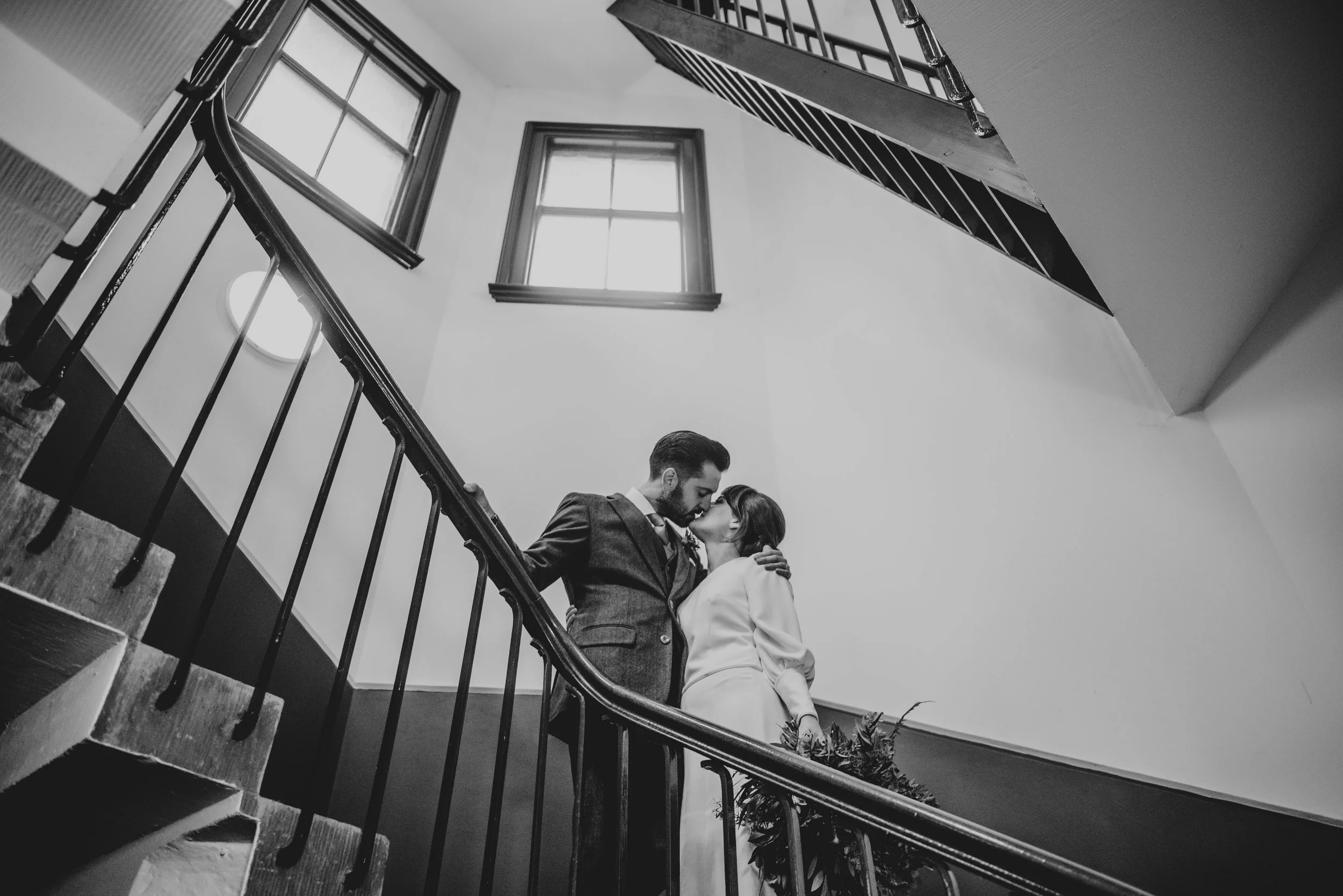 Bride and Groom kiss on stairwell at Round Chapel London Essex Documentary Wedding Photographer