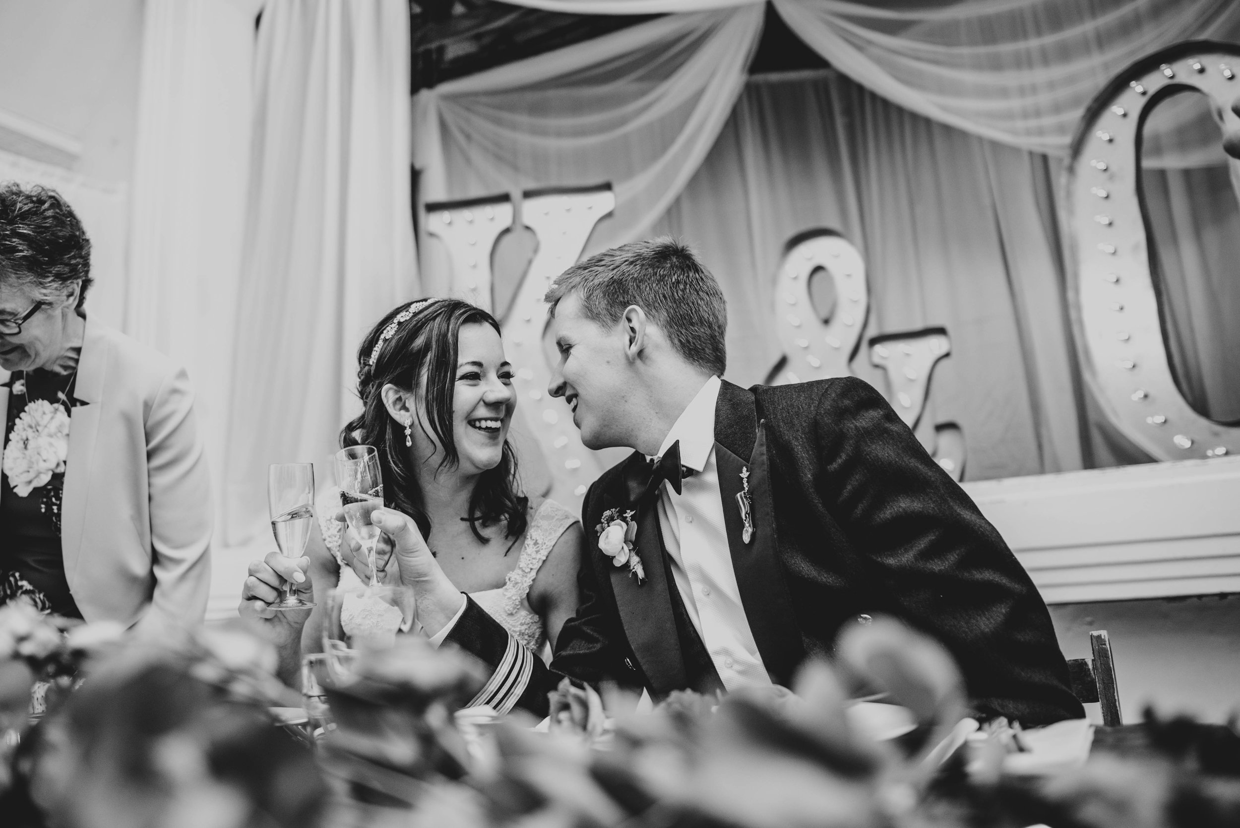 A Rustic DIY Spring Wedding St Nicholas' Church, Chawton & Chichester Hall, Witley. With trestle tables, wild flowers in bottles. Bride wears Pronovias. Essex Documentary Wedding Photographer