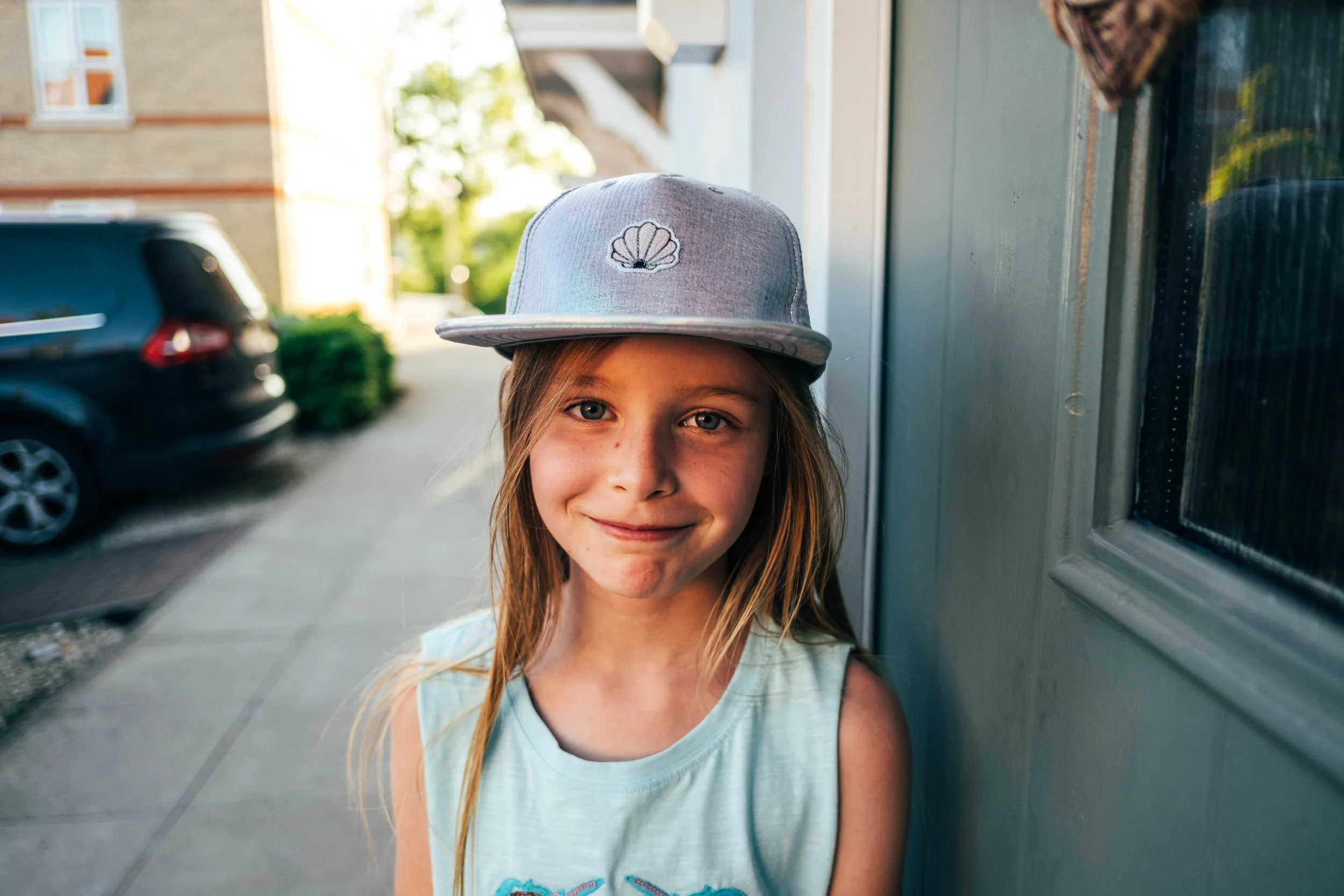 Little girl in cap smiles Essex Documentary Family and Wedding Photographer