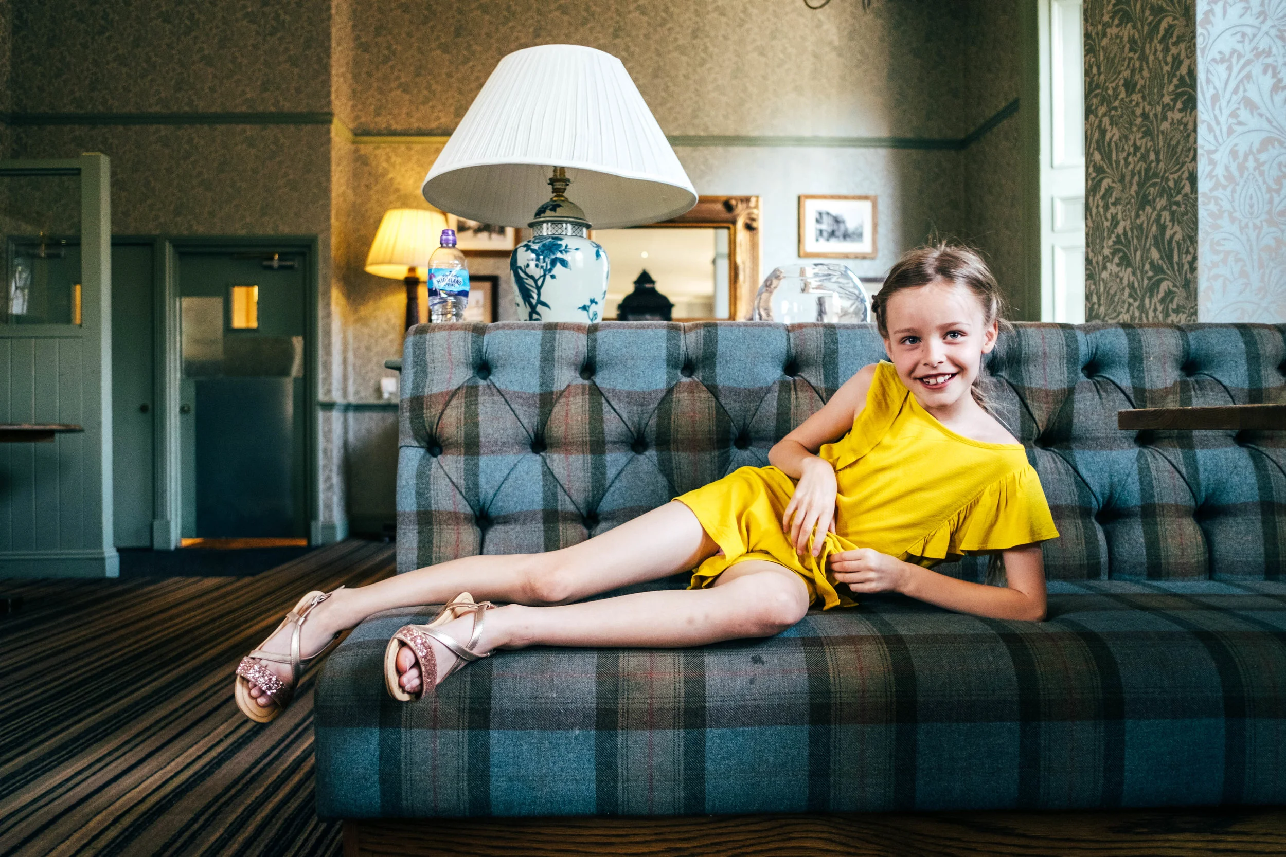 Little girl lazes on sofa in hotel Essex Documentary Family and Wedding Photographer 