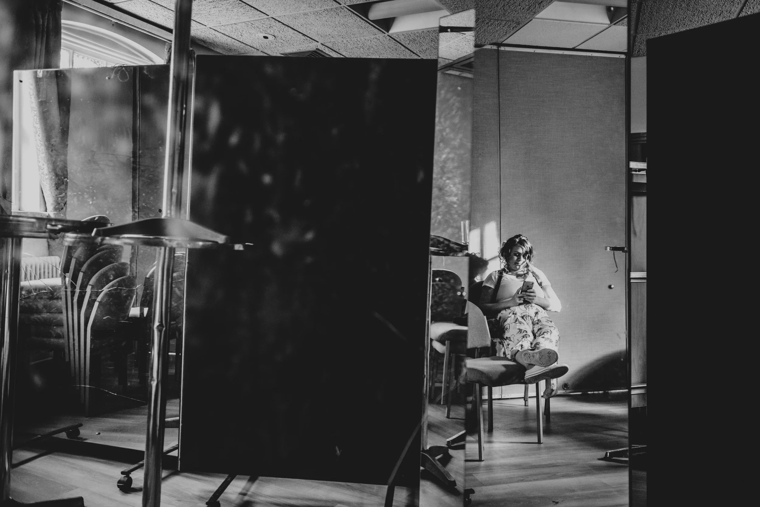 Woman sits on chair in sunlit room mirror reflection Essex Documentary wedding and Family Photographer