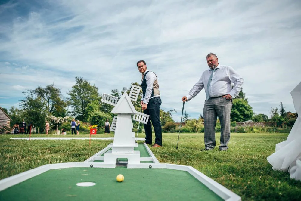 Rustic Summer wedding at Ratsbury Barn with Mini Golf, lawn games, pizza and home-made cake. Bride wears Mori Lee. Essex Documentary Wedding Photographer