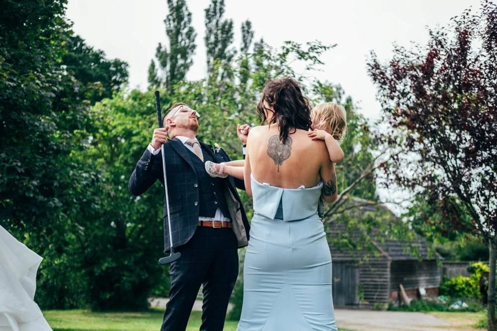 Rustic Summer wedding at Ratsbury Barn with Mini Golf, lawn games, pizza and home-made cake. Bride wears Mori Lee. Essex Documentary Wedding Photographer