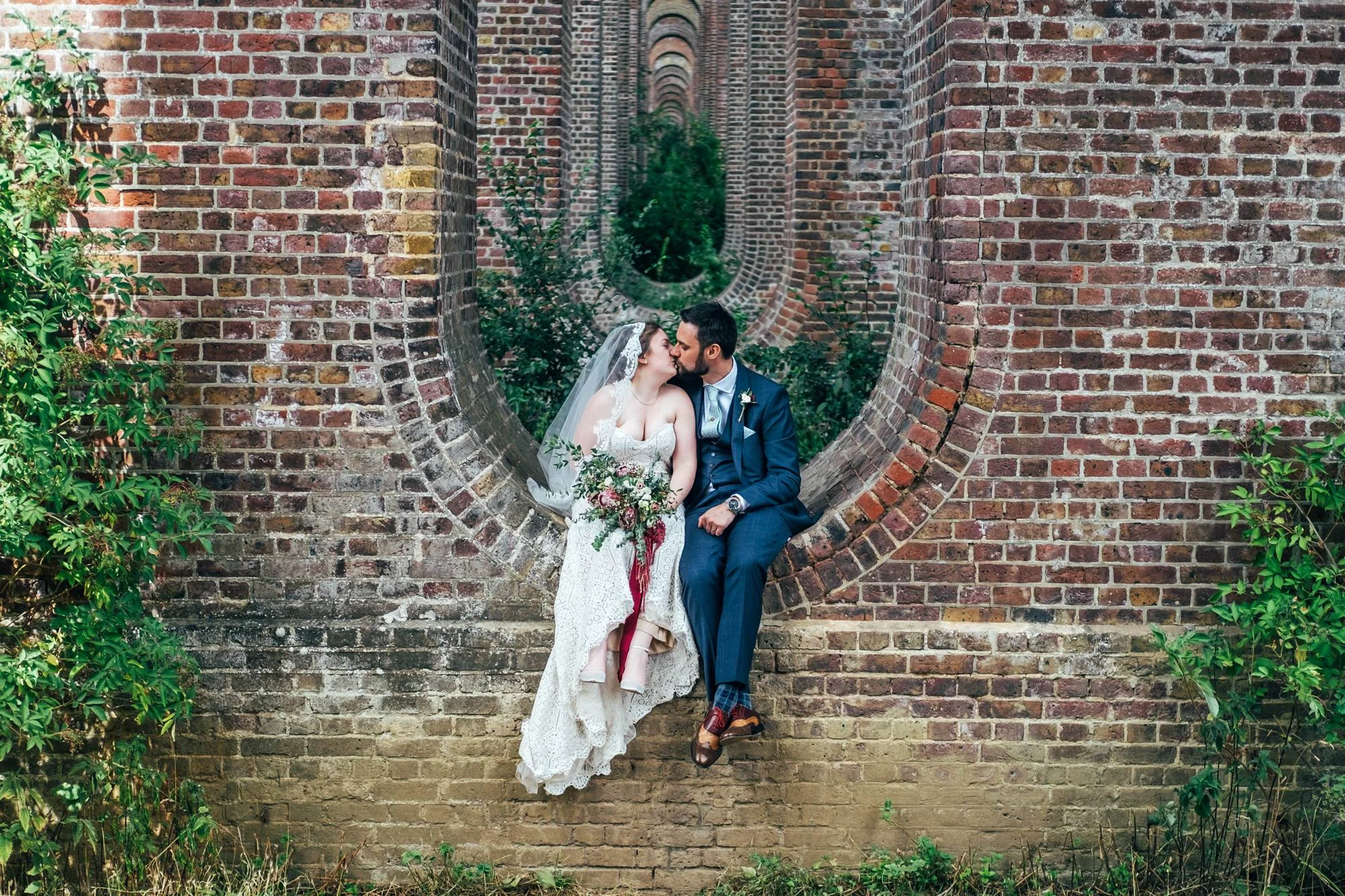 East Anglian Railway Museum Wedding. Vintage lace with Red &amp; Light Blue Palette with Proteas Bouquet. Essex Documentary Wedding Photographer