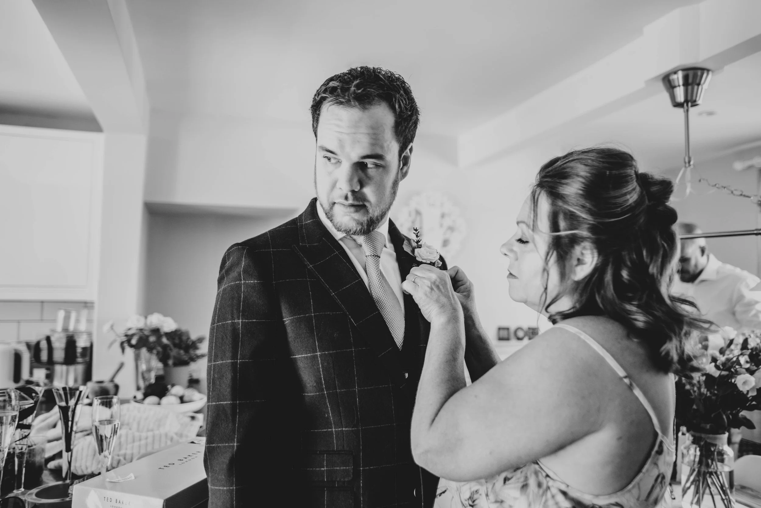 Grooms mum pins button hole on him for Ratsbury Barn Wedding.   Essex Documentary Wedding Photographer