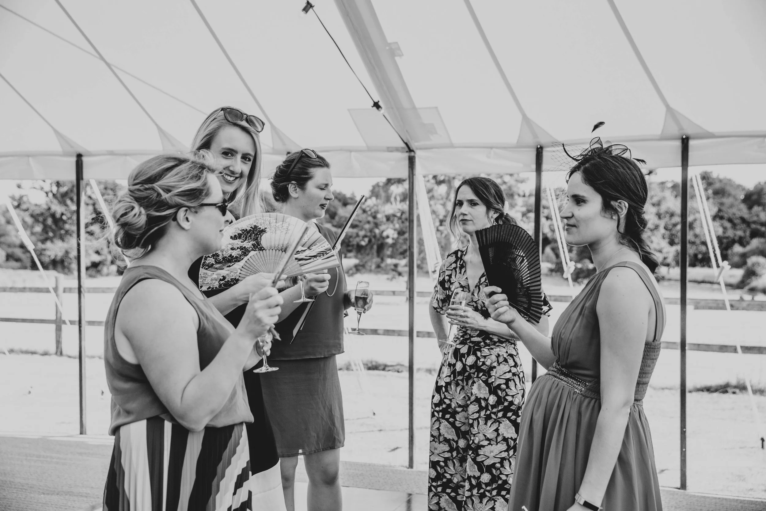 Wedding guests fan themselves Summer Wedding, Essex Documentary Wedding Photographer