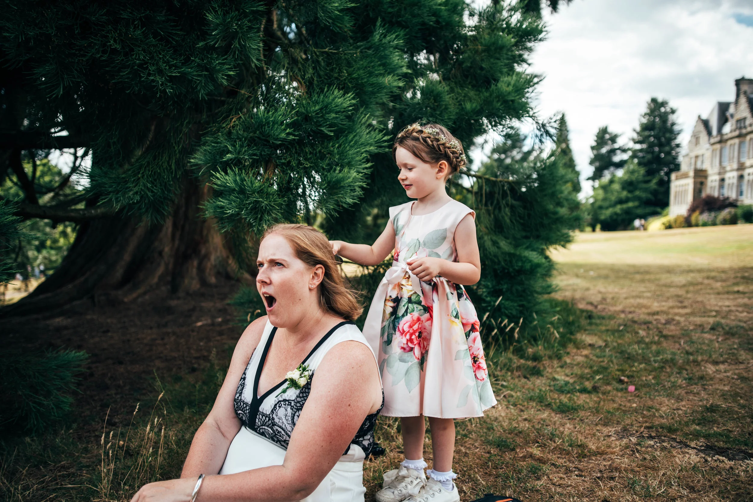 Flower girl brushes Mum's hair at Ashdown Park Hotel Wedding Essex Documentary Wedding Photographer