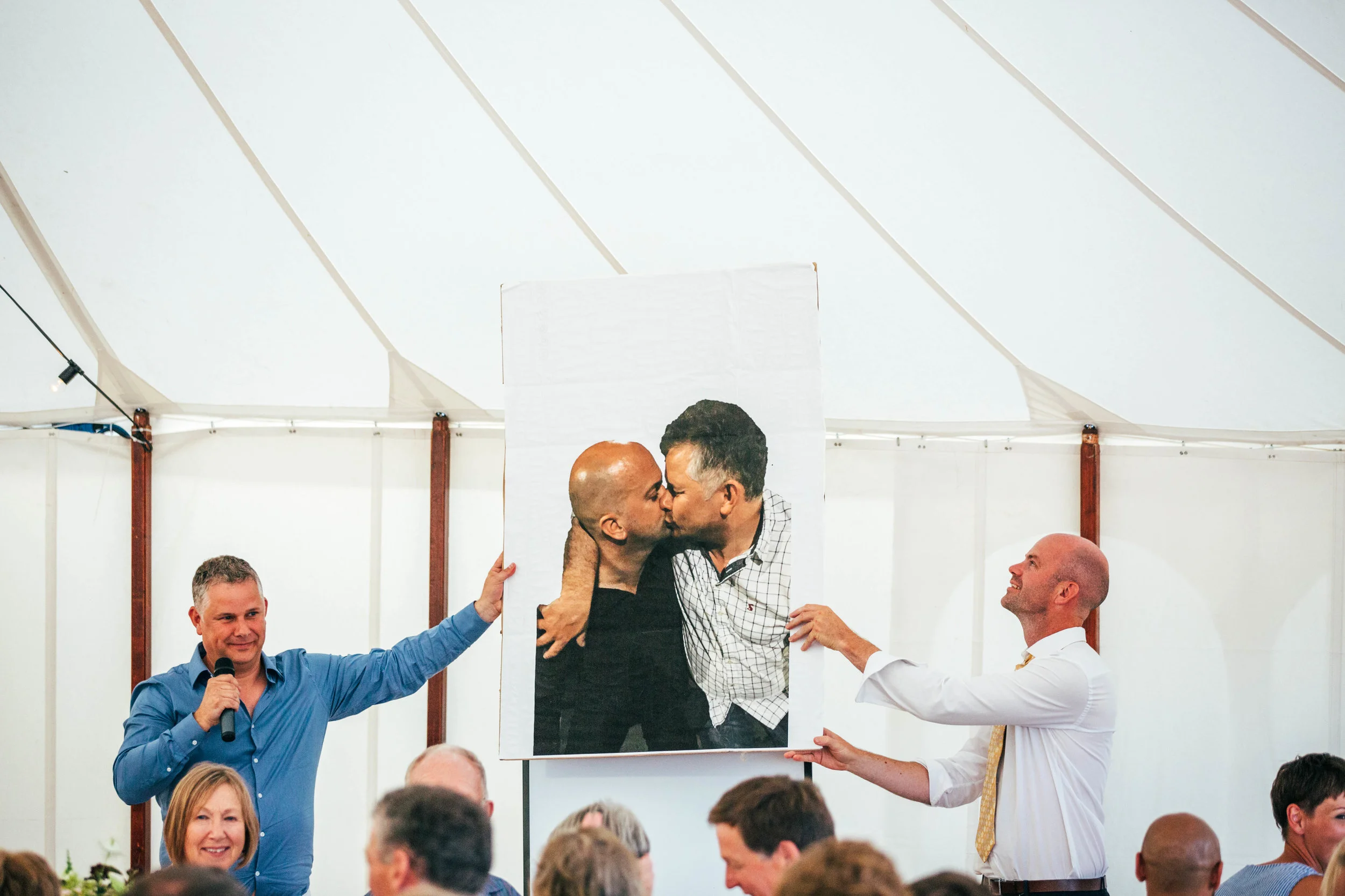 Best men hold up photo of Groom during speeches. Essex Documentary Wedding Photographer