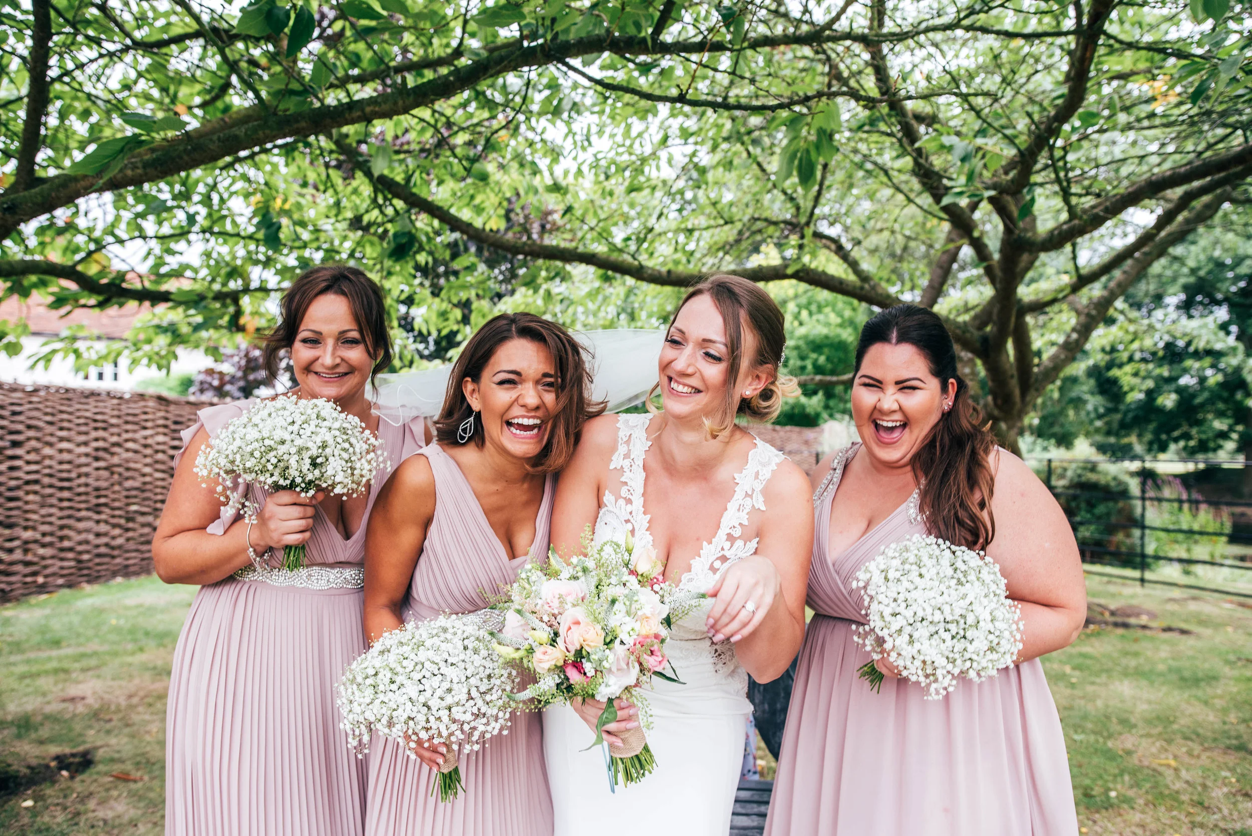 Bride laughs with Bridesmaids in Pink for Blake Hall, Ongar Wedding Essex Documentary Wedding Photographer