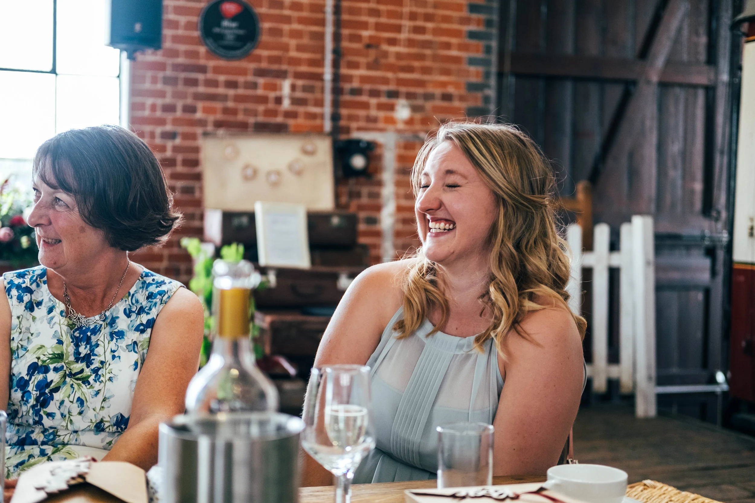 Bridesmaid laughs at speeches at East Anglian Railway Museum, Essex Documentary Wedding Photographer