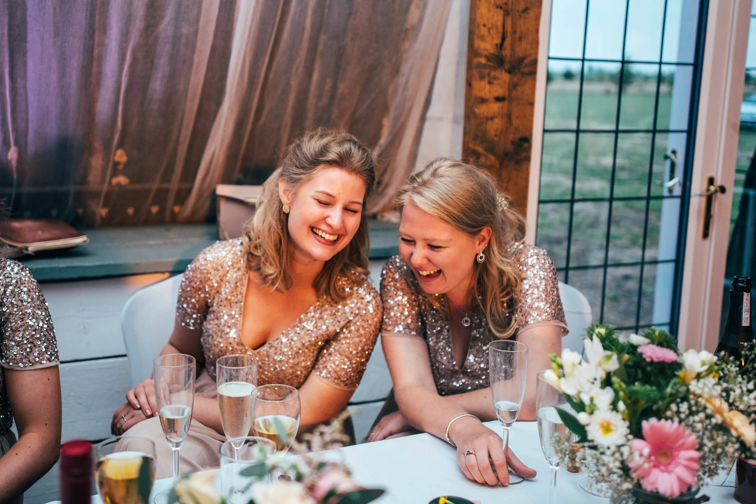 Bridesmaids laugh at speeches, Bedinghams Farm, Ely, Essex Documentary Wedding Photographer