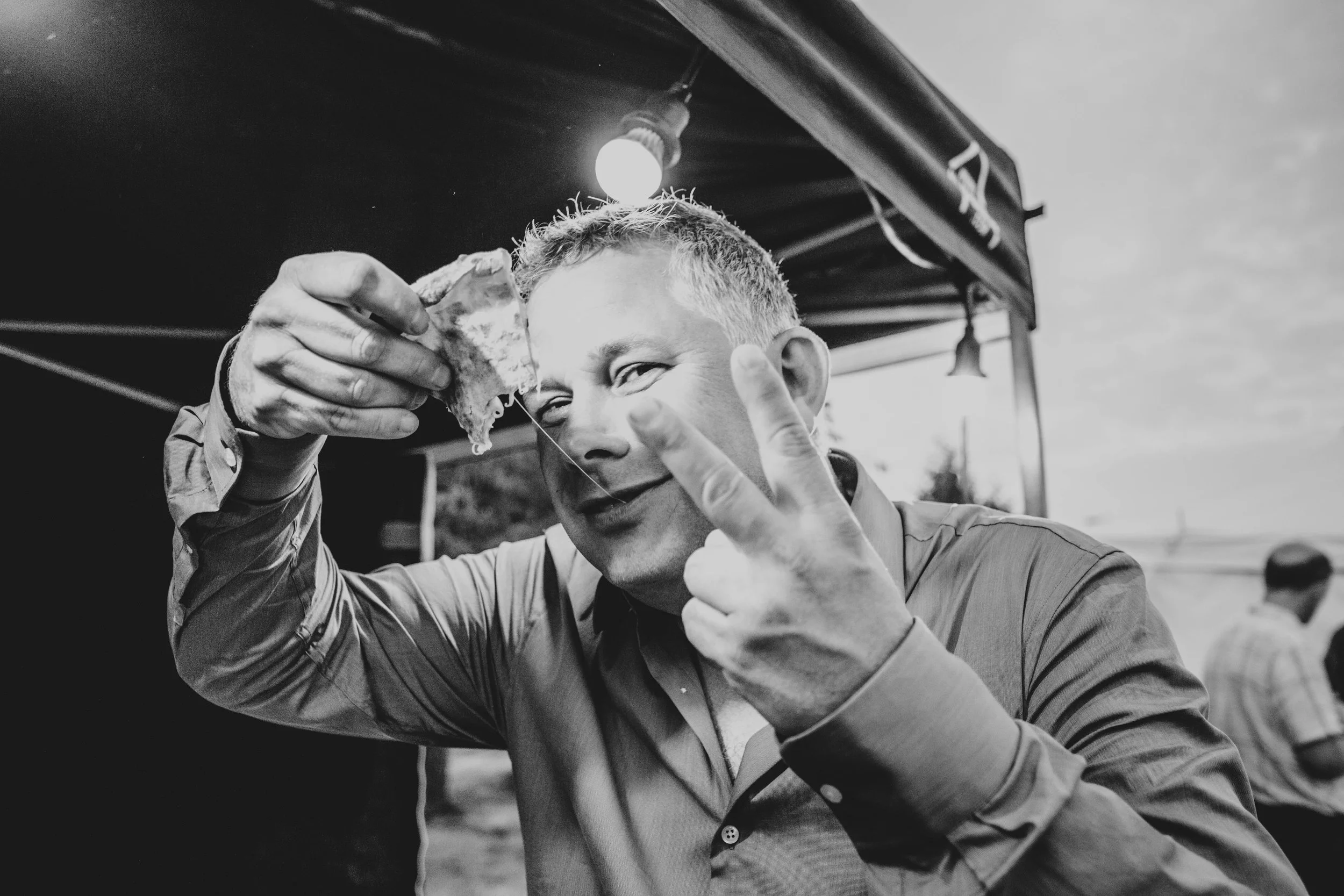 Wedding guest eats pizza at outdoor wedding, Essex Documentary Wedding Photographer