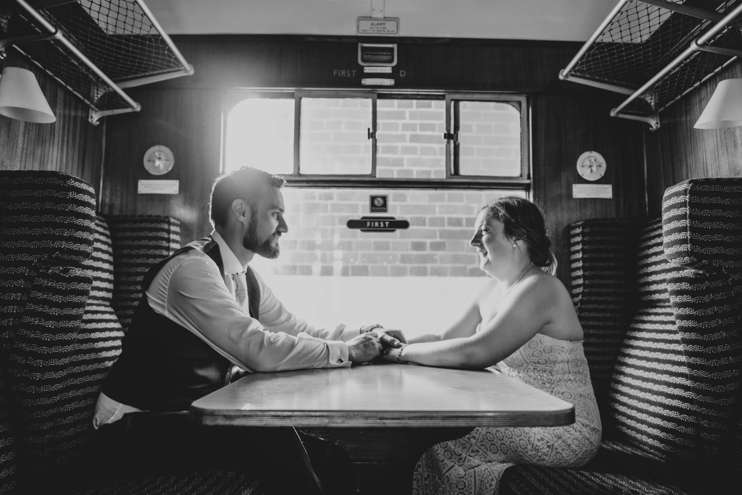 Bride and Groom hold hands on train at East Anglian Railway Museum, Essex Documentary Wedding Photographer