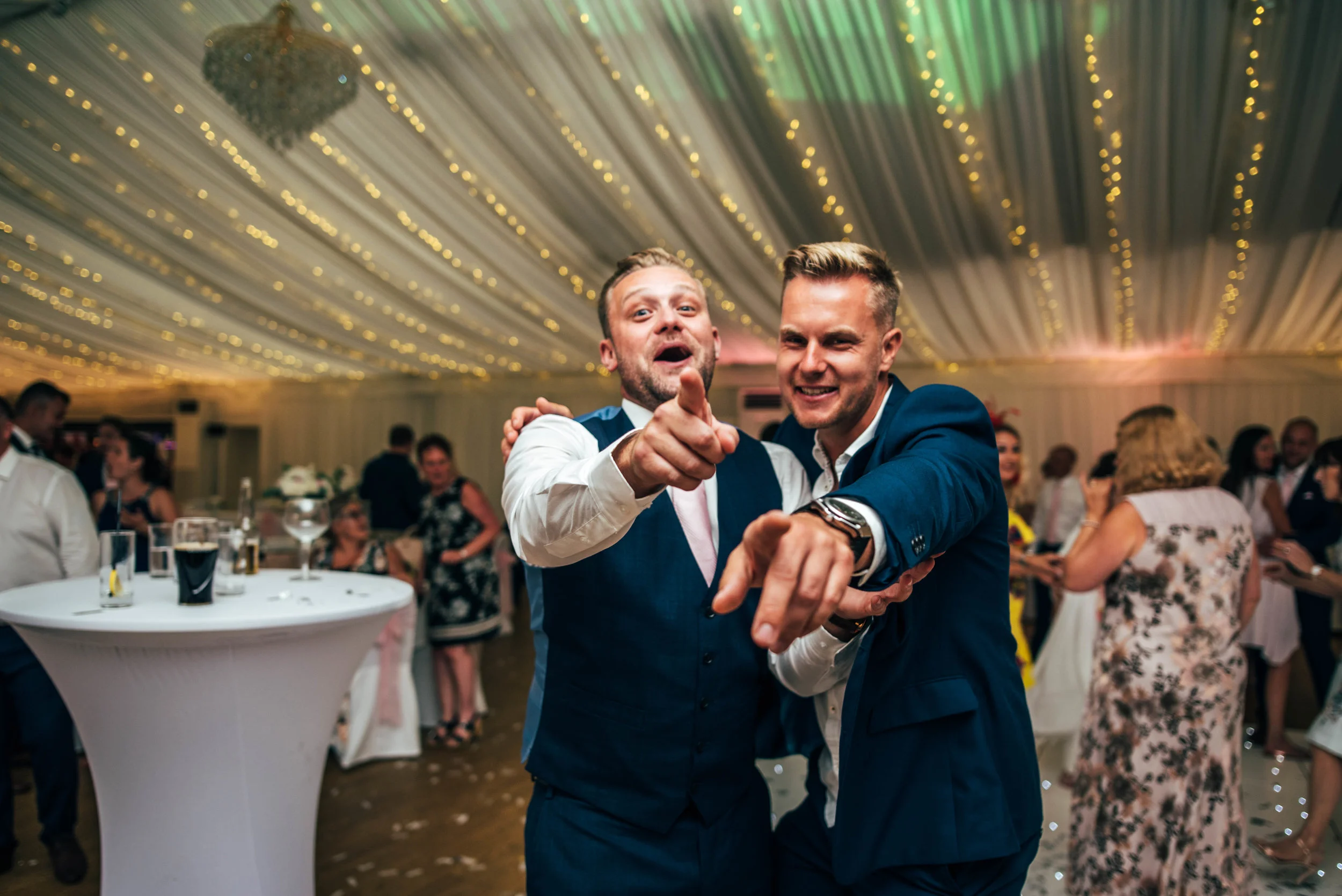wedding guests on dance floor laugh at camera Quendon Hall, Essex Documentary Wedding Photographer