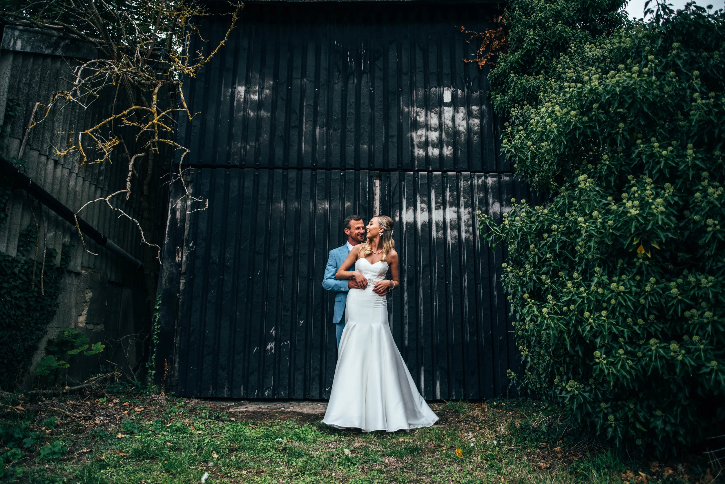 Bride and Groom outside barn at Fennes, Braintree, Essex Documentary Wedding Photographer