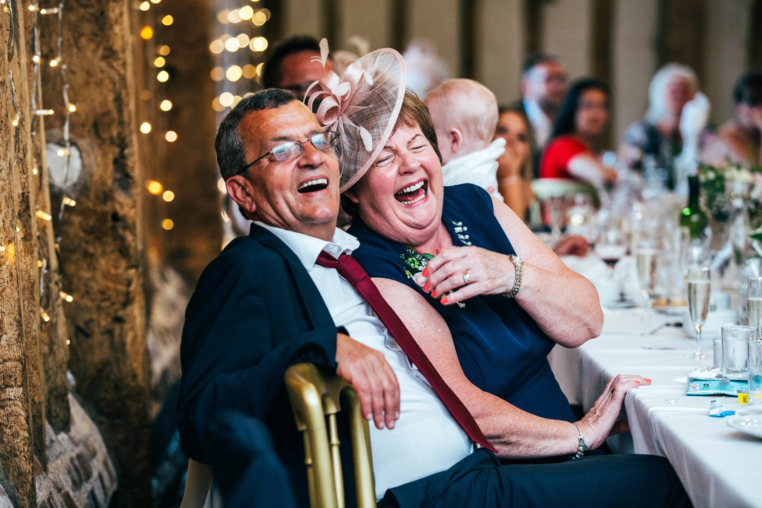 Parents of the Groom laugh at speeches at Blake Hall, Ongar, Essex Documentary Wedding Photographer