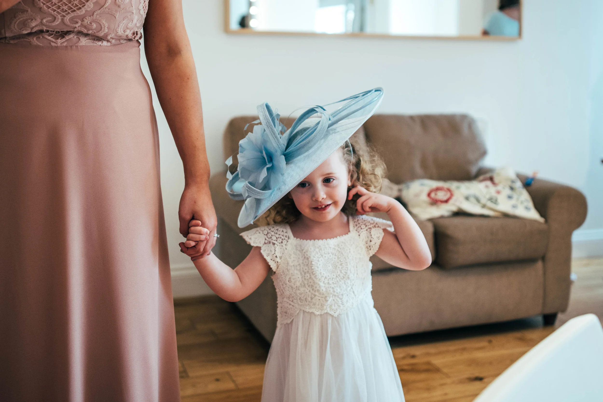 Flower girl tries on ladies hat at Blake Hall Ongar Spring Wedding