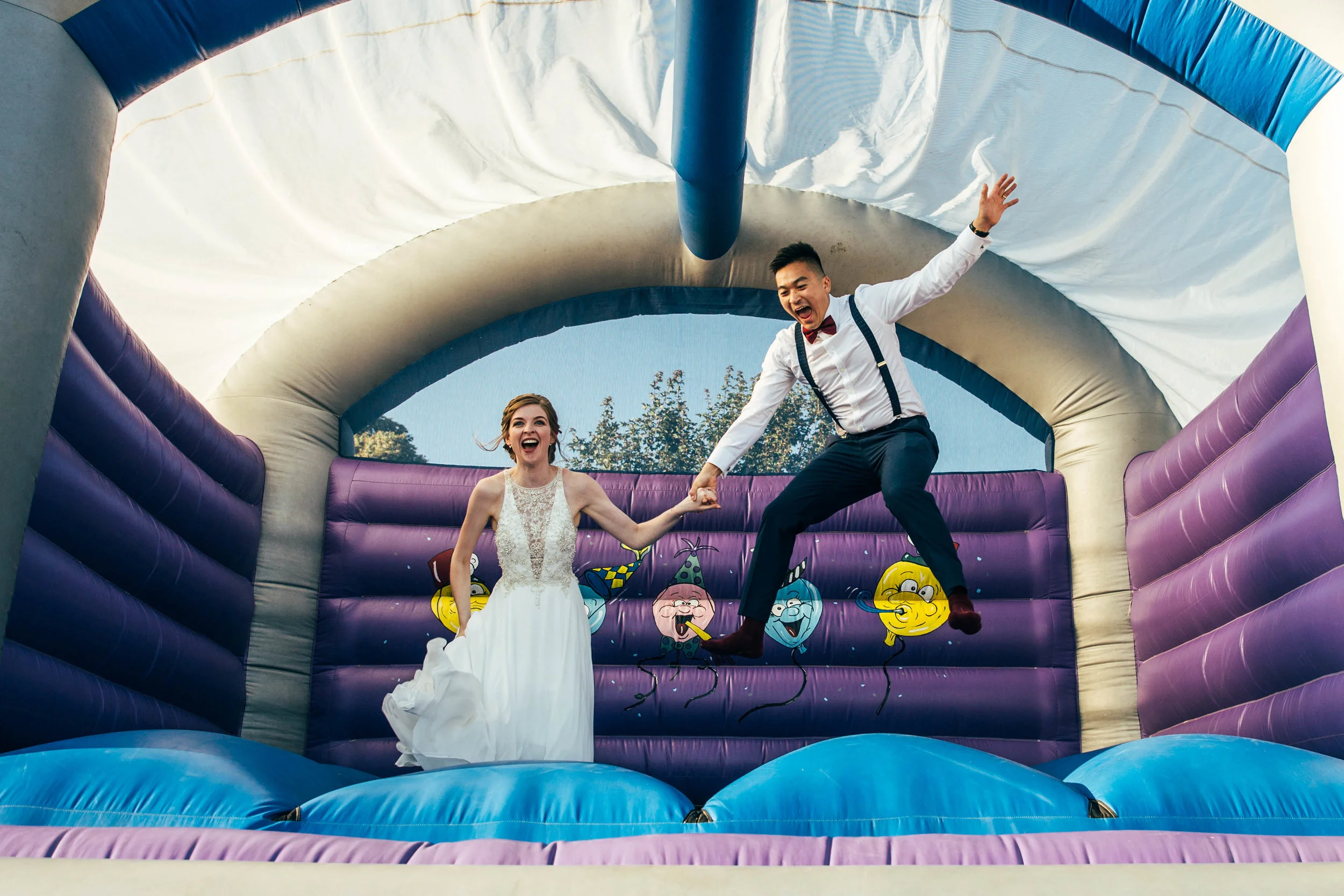Bride & Groom on bouncy castle Essex Documentary Wedding Photographer