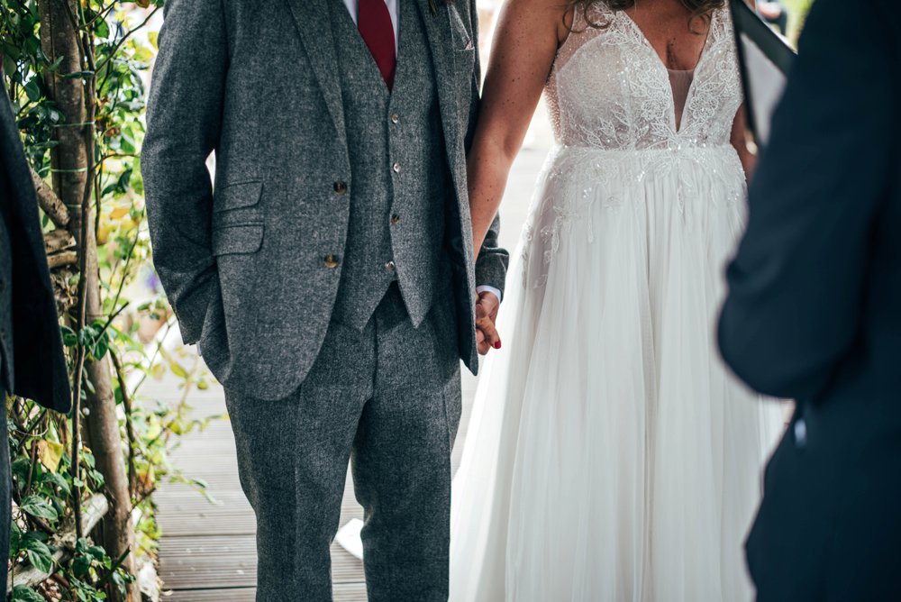 Lush, Vibrant Reds and Tweed for a Movie inspired Barn wedding at The House Meadow with Bridesmaids in Jumpsuits and a Festival Vibe. Essex Documentary Wedding Photographer