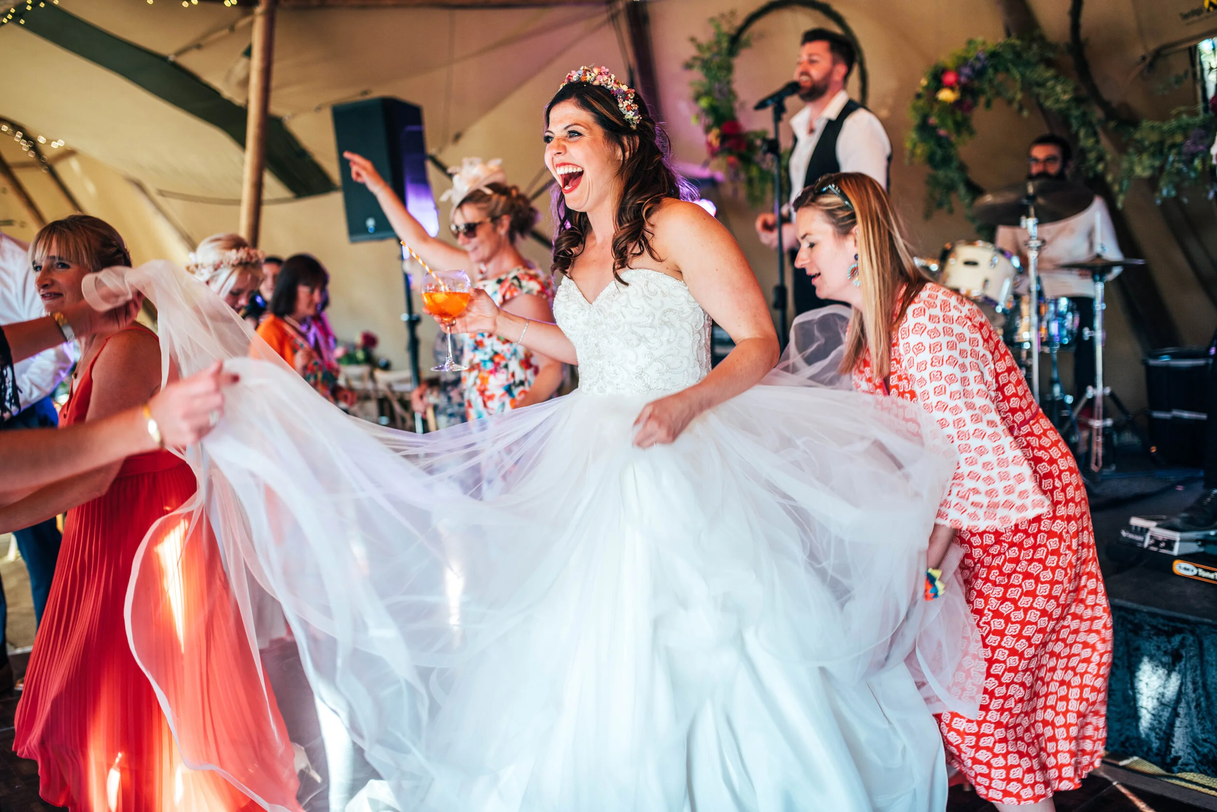 Guests lift Brides dress on dance floor Back Garden DIY Tipi Wedding. Essex Documentary Wedding Photographer. Three Flowers Photography