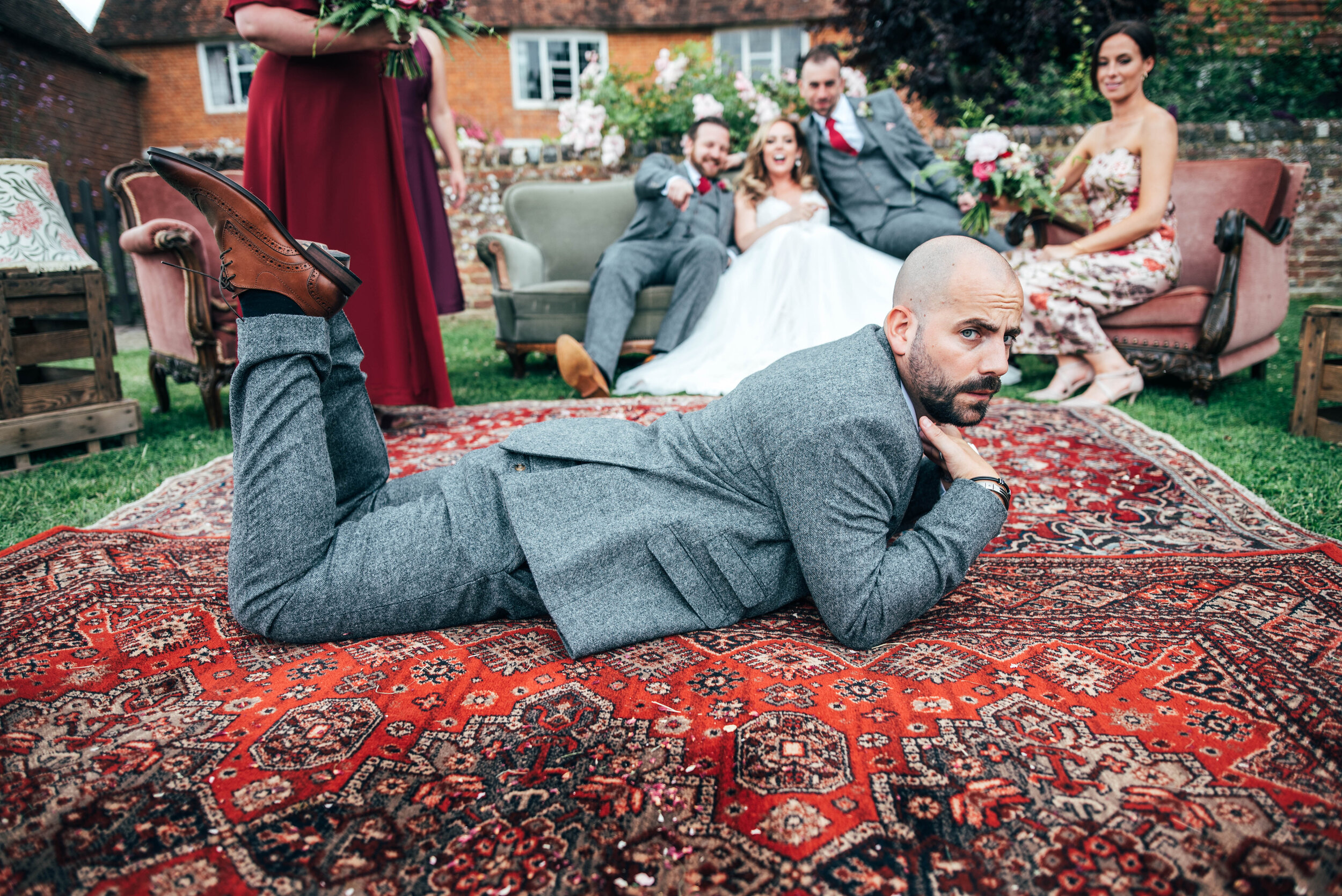 Best Man poses on a rug at Farm Wedding, The House Meadow, Kent Essex Documentary Wedding Photographer. Three Flowers Photography
