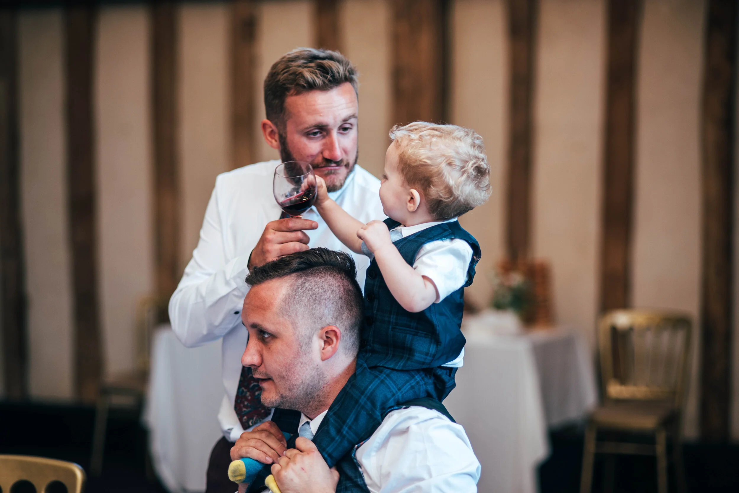 Toddler tries to steal guest wine at Blake Hall. Essex Documentary Wedding Photographer. Three Flowers Photography