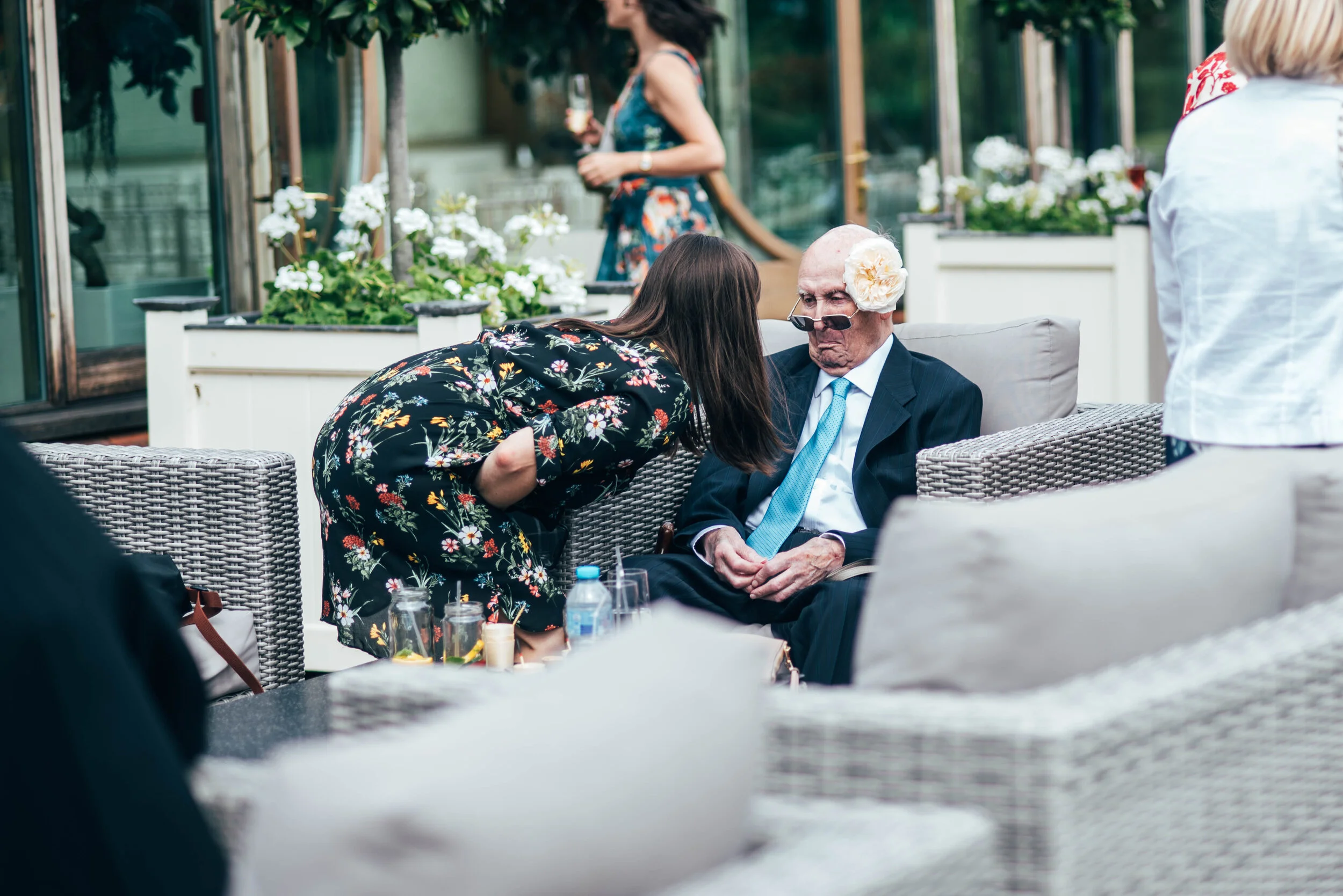 Guest puts flower on Grandad's head at Gaynes Park. Essex Documentary Wedding Photographer. Three Flowers Photography