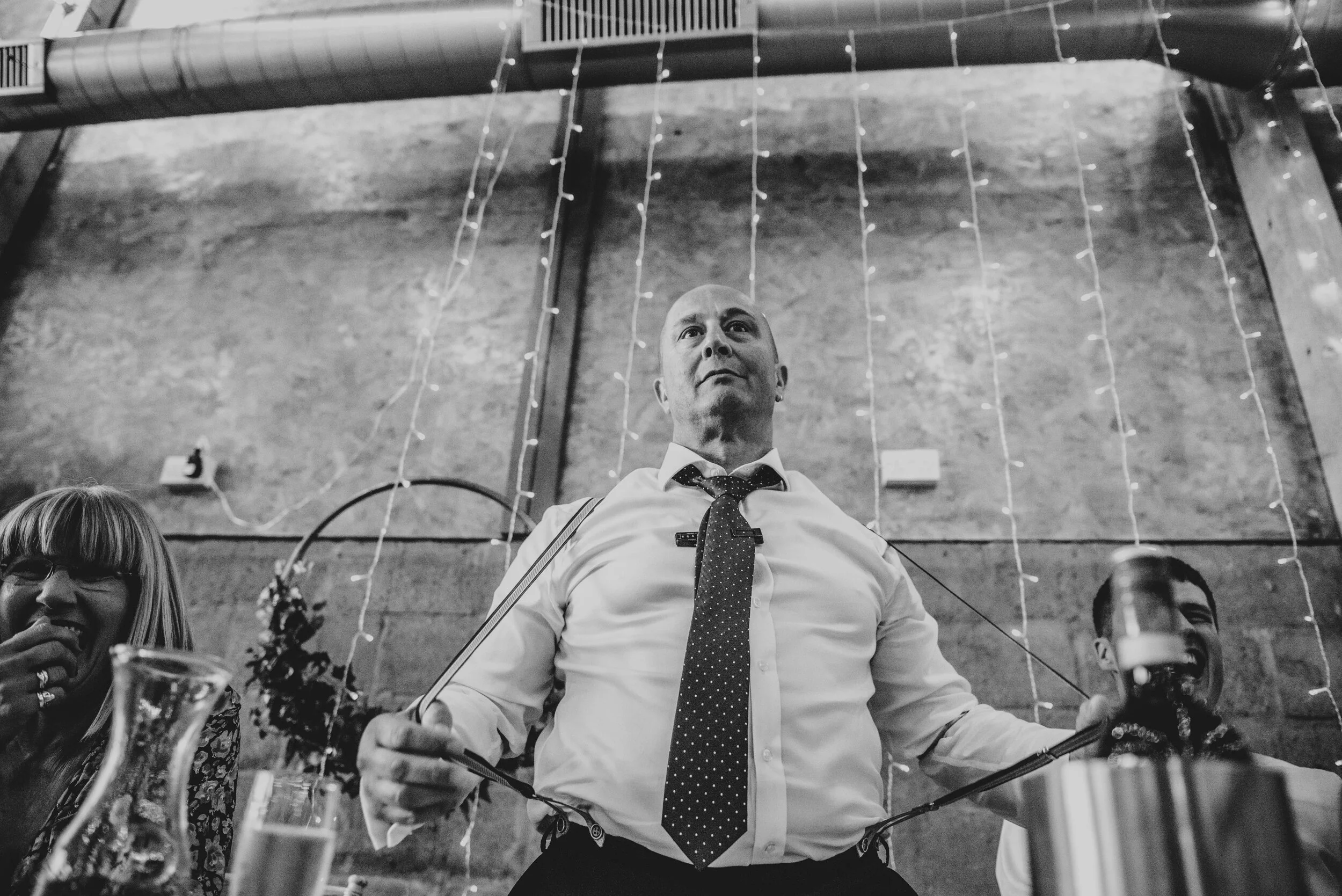 Grooms Dad pings his braces during speeches at The Barns at Lodge Farm. Essex Documentary Wedding Photographer. Three Flowers Photography