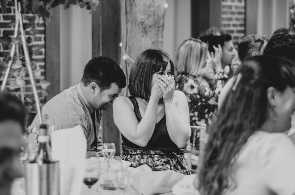 Guest covers her face in embarrassment speeches at Gaynes Park Top Essex documentary wedding photographer
